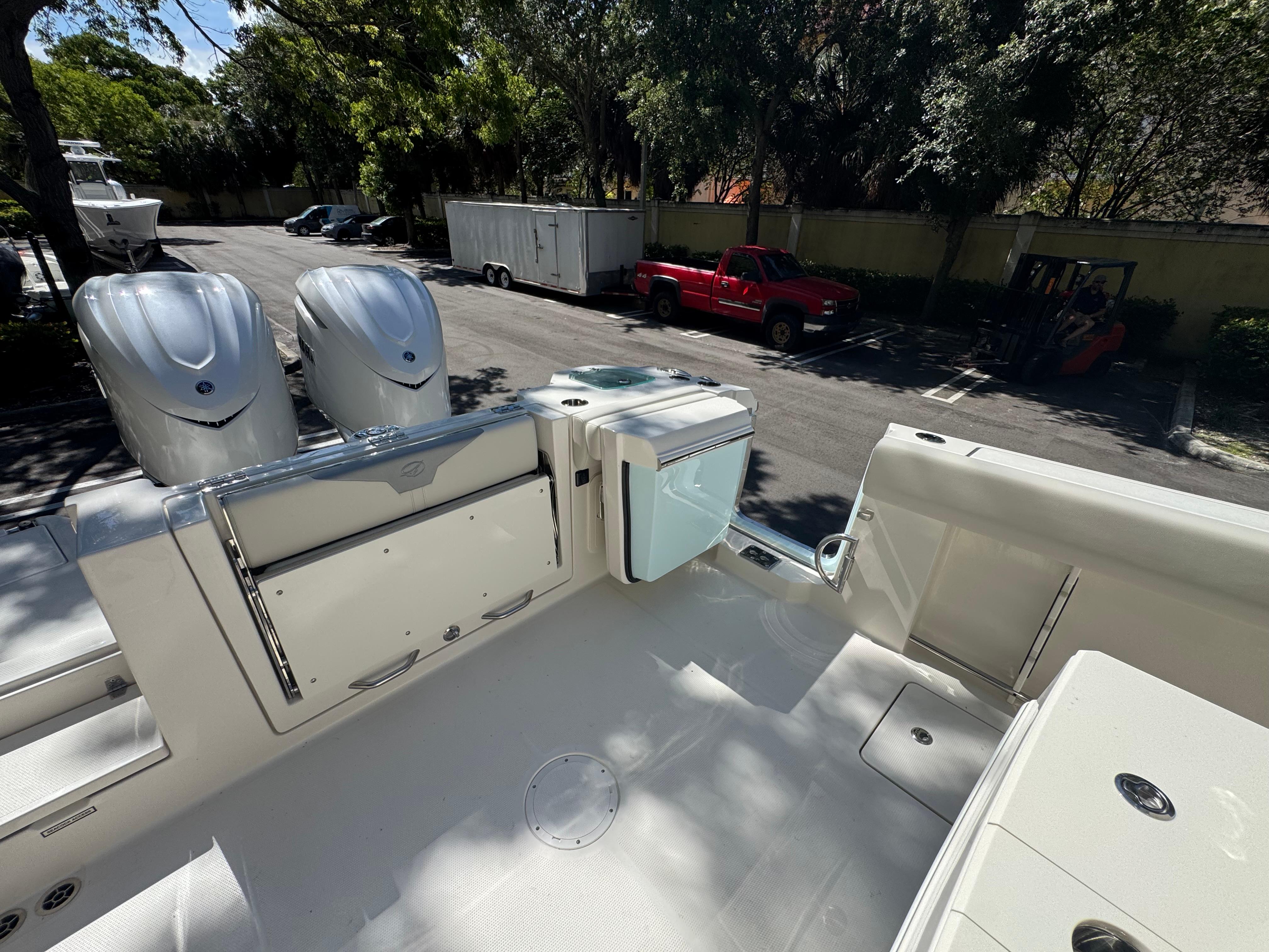 2026 Sailfish 312 CC boat with dual engines, parked outdoors in a sunny setting.