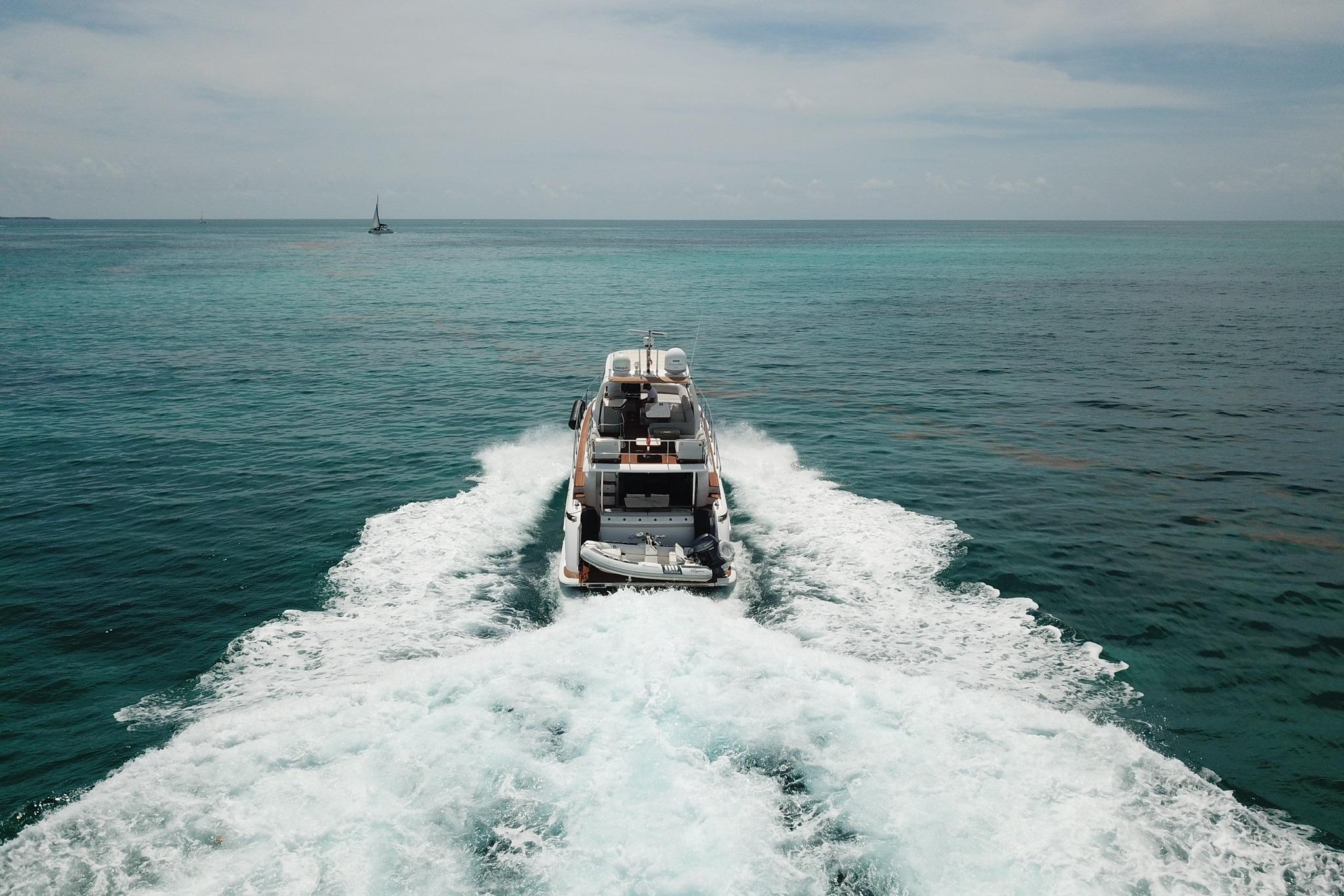 Azimut 55 yacht cruising on open sea, 2021 model, leaving a wake behind.