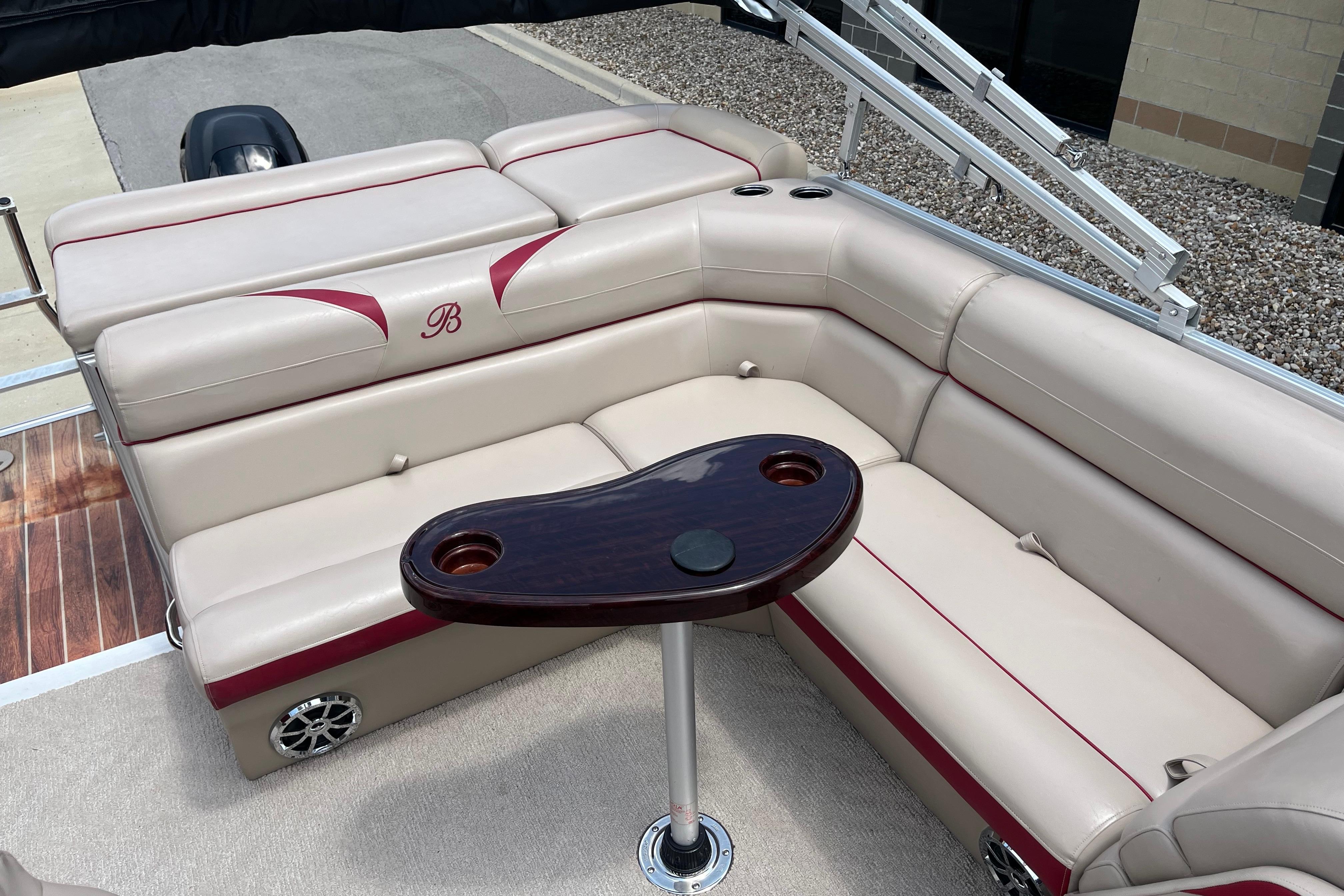 Luxurious seating area on a 2013 Berkshire 230CL CTS pontoon boat with a wooden table.
