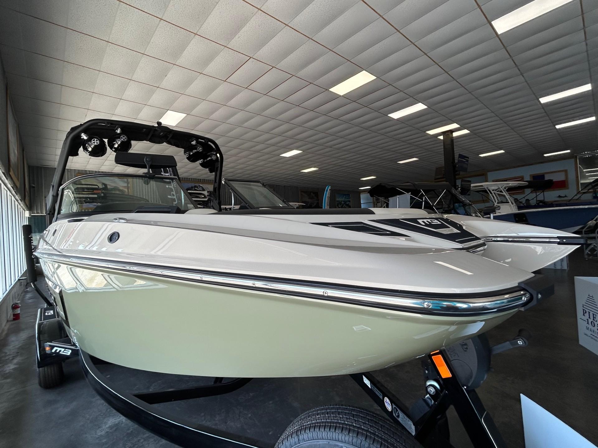2024 MB F22 Tomcat boat in showroom, sleek design, black and white color scheme.