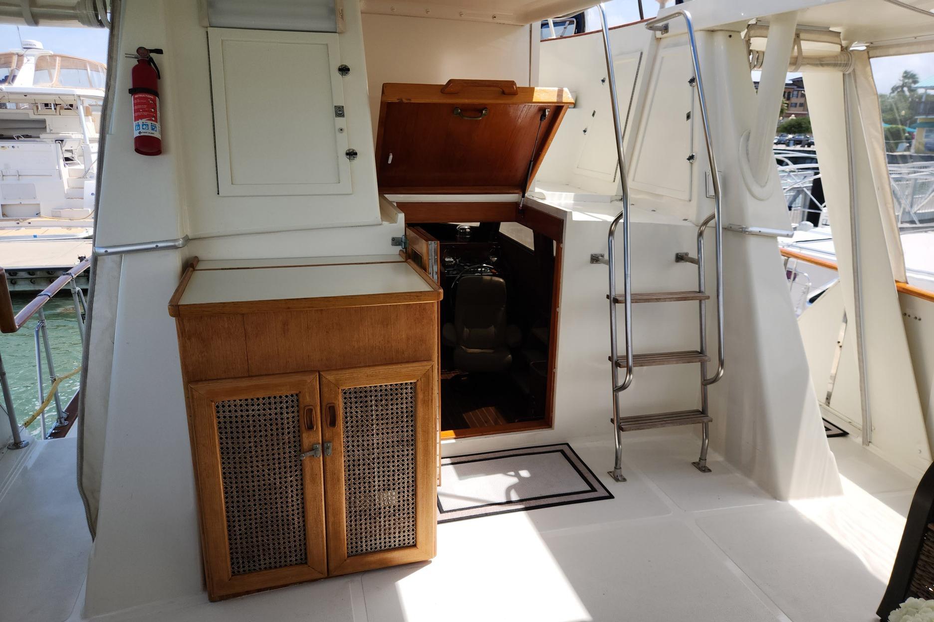 1980 Gulfstar 44 Motor Cruiser interior with wooden cabinetry and ladder, docked at marina.
