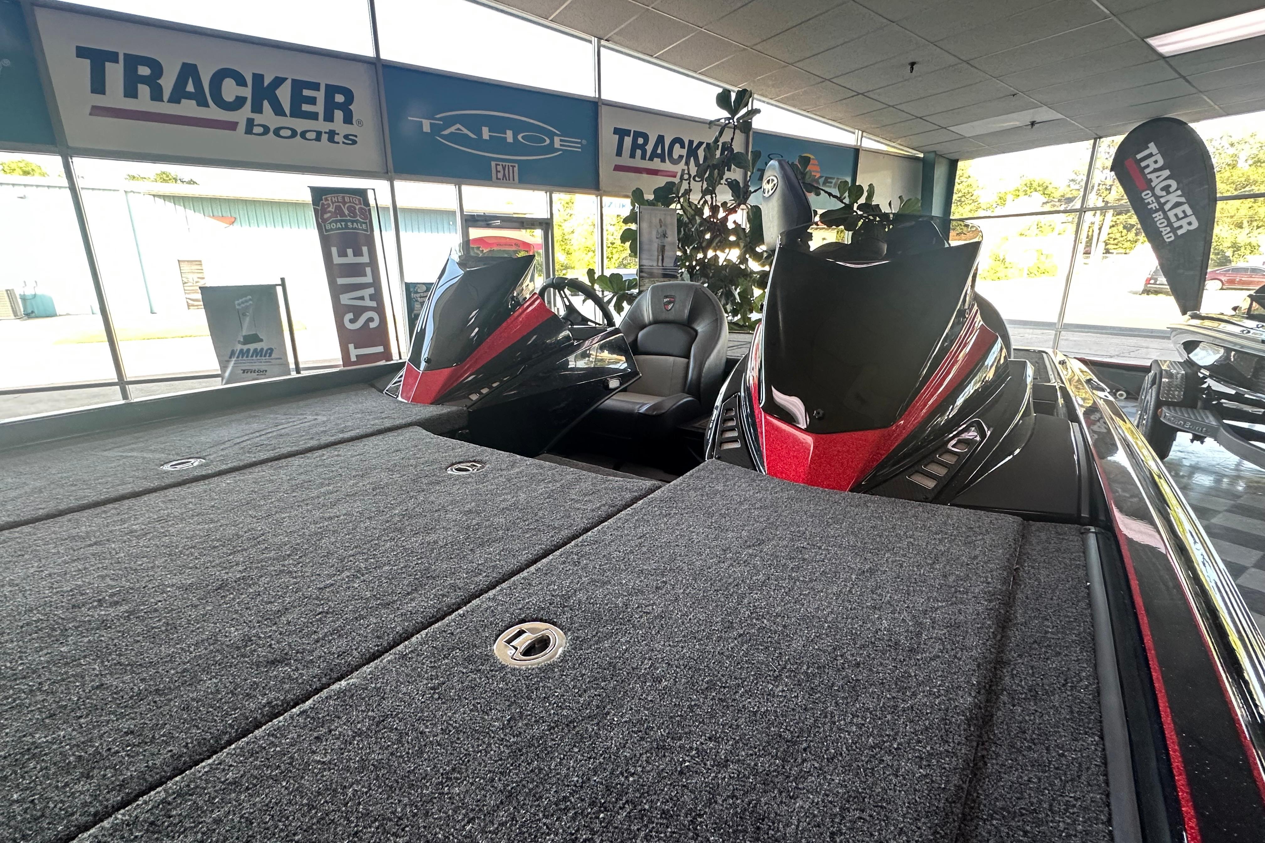 2026 Triton 20XP Patriot boat displayed in showroom with Tracker and Tahoe signage.