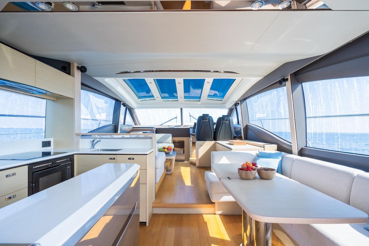 Luxurious interior of 2019 Princess V60 yacht with modern kitchen and seating area.