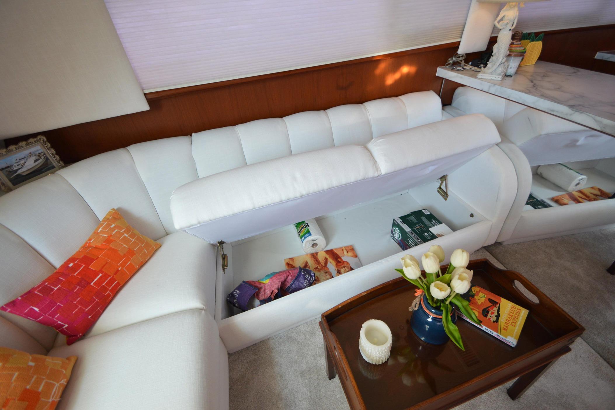 Luxurious 1995 Ocean 48 Cockpit Motor Yacht interior with white seating and hidden storage.