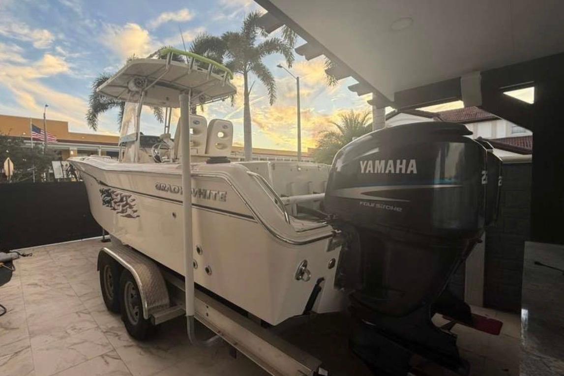 2004 Grady-White Chase 273 boat with Yamaha engine on trailer, palm trees in background.