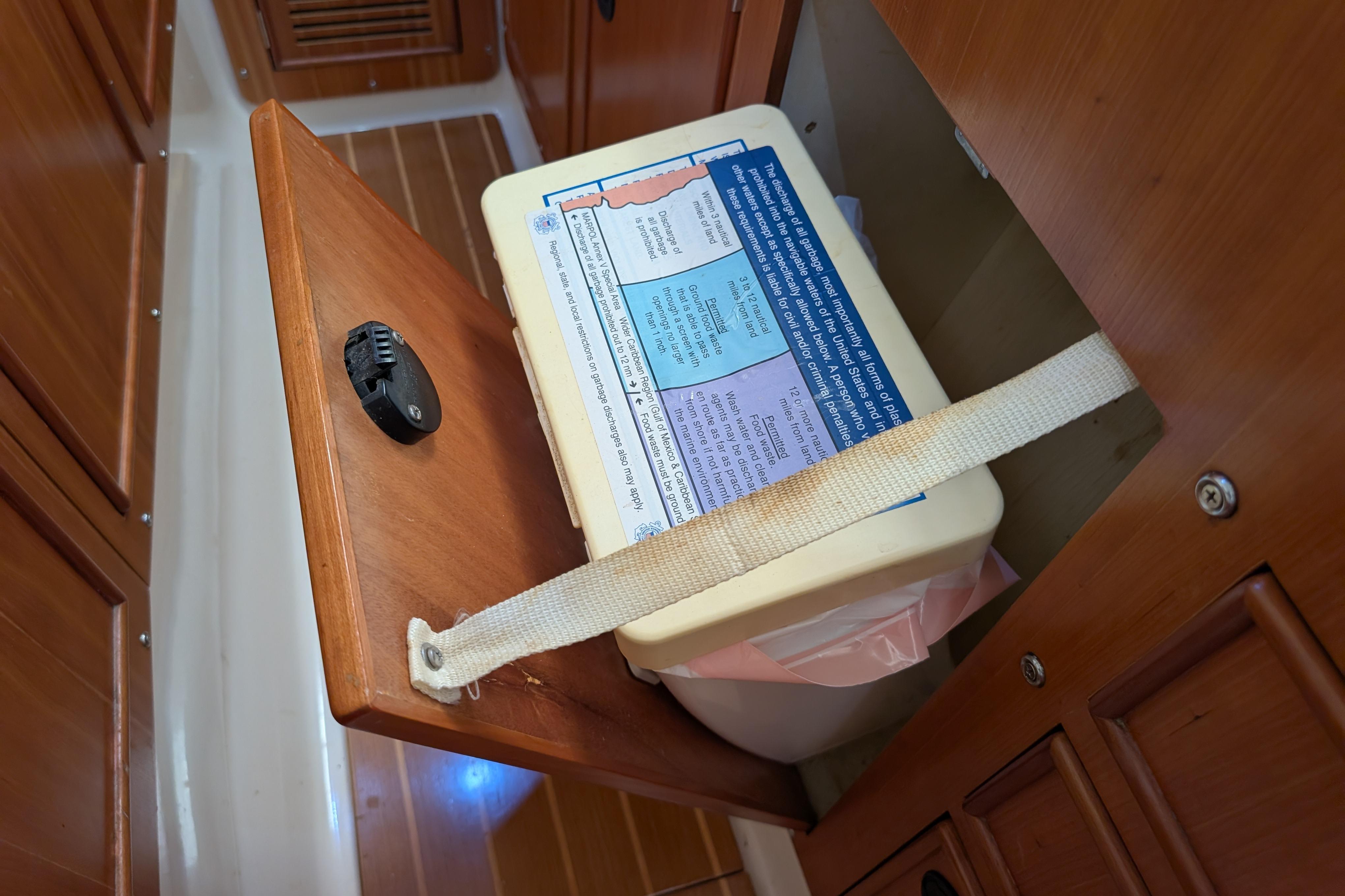 Storage compartment with secured container inside a 2004 PDQ 34 Powercat boat interior.