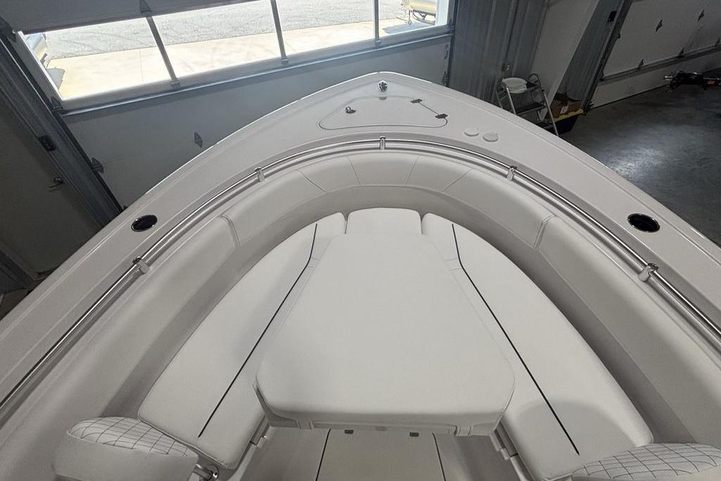 2026 Sportsman Open 252 Center Console boat interior with cushioned seating in a garage.
