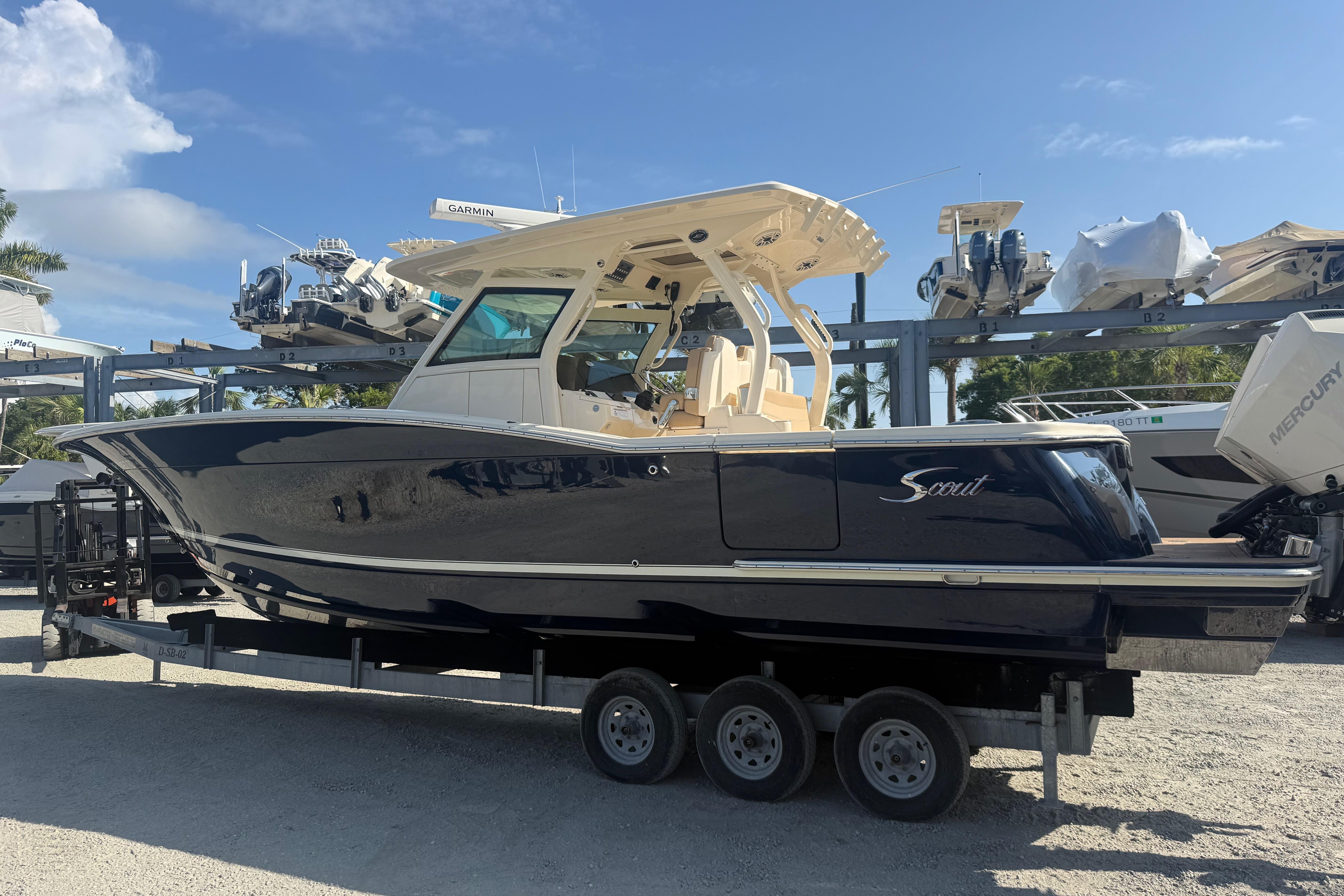 2022 Scout 355 LXF boat on trailer, displayed outdoors under clear blue sky.