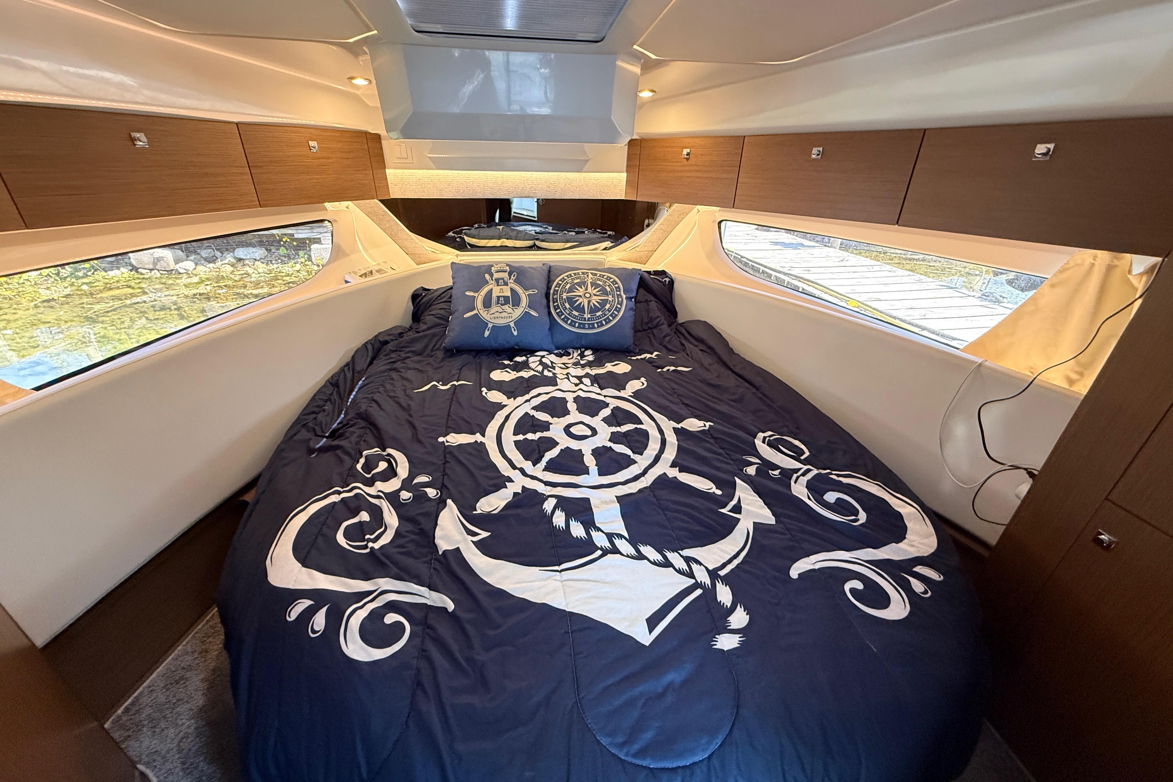 Luxurious cabin interior of 2022 Jeanneau NC 1095 Fly with nautical-themed bedding.