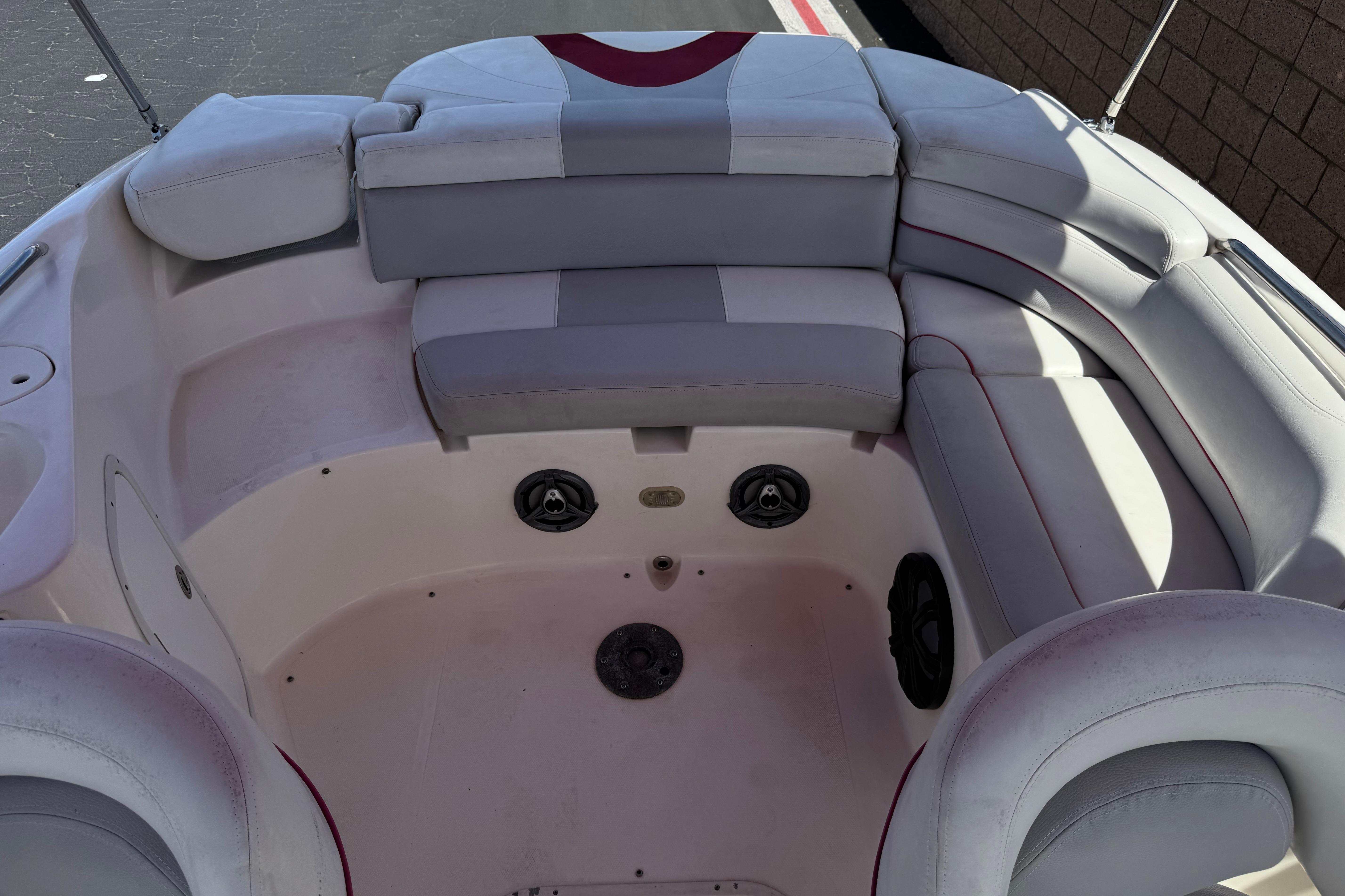 Interior seating of a 2010 Bryant 255 boat, featuring cushioned benches and speakers.