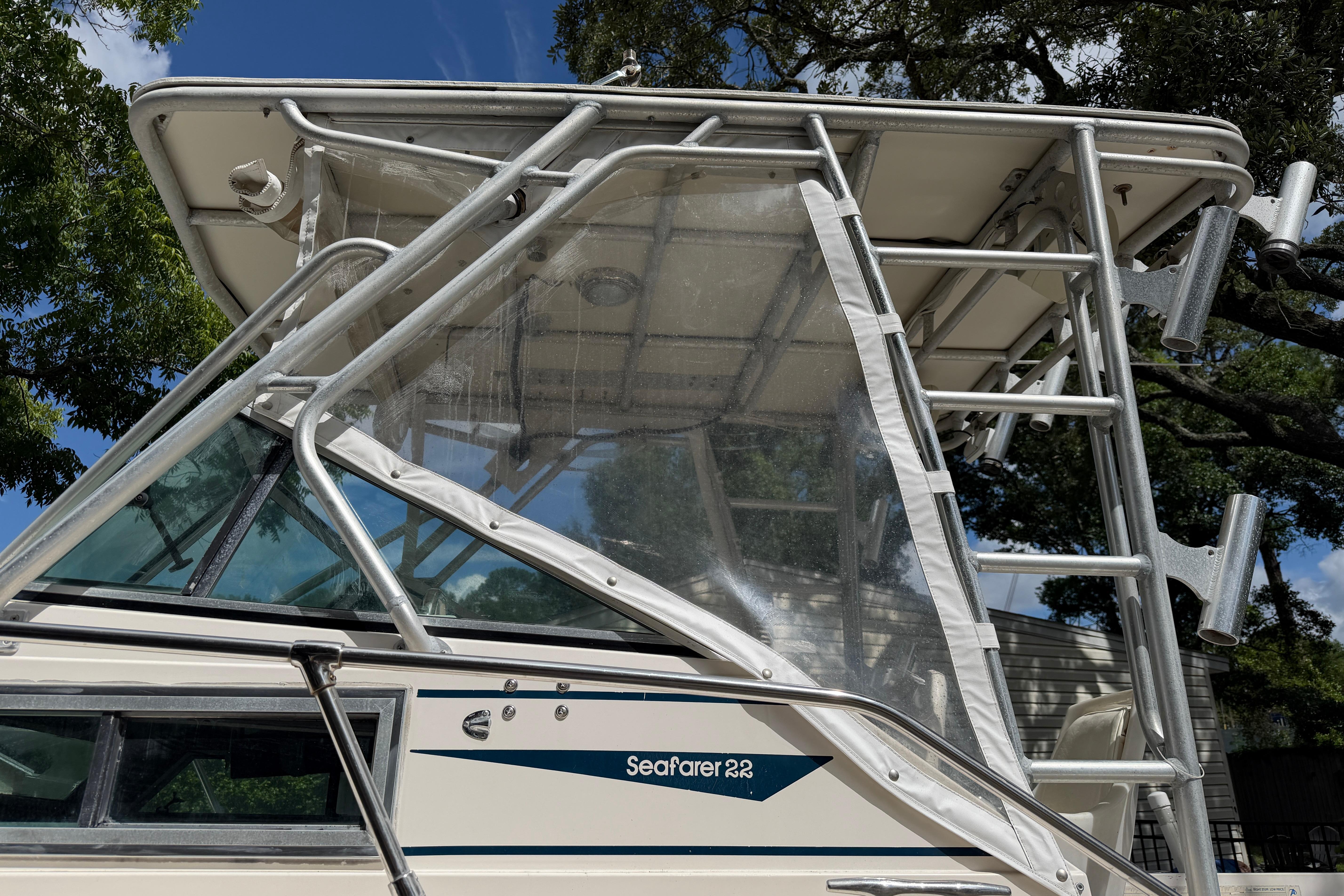 1987 Grady-White Seafarer 226 boat with clear canopy and metal framework under blue sky.