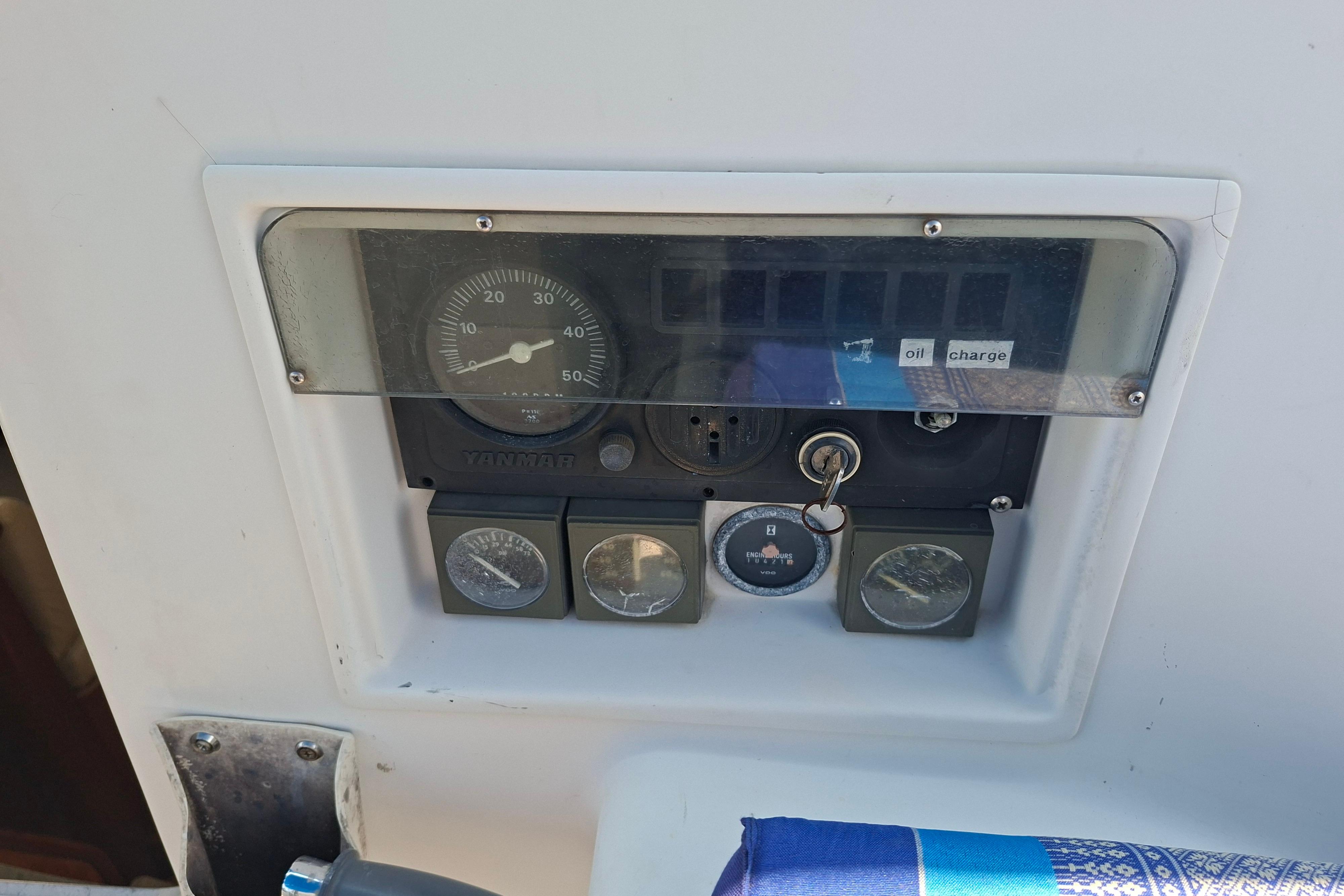 Control panel of a 1999 Beneteau Oceanis 40 CC sailboat, featuring gauges and ignition key.