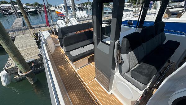 Modern Nimbus T11 boat interior with sleek seating and wooden deck, docked at a marina.