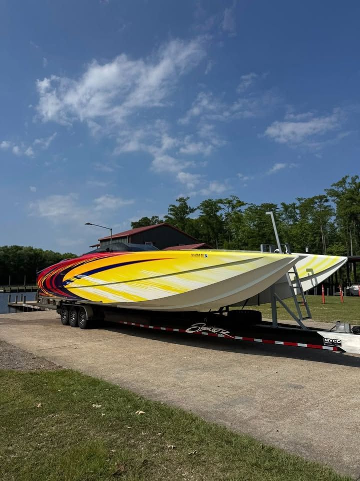 2003 Skater 40 S.S. boat on trailer, yellow-red striped.