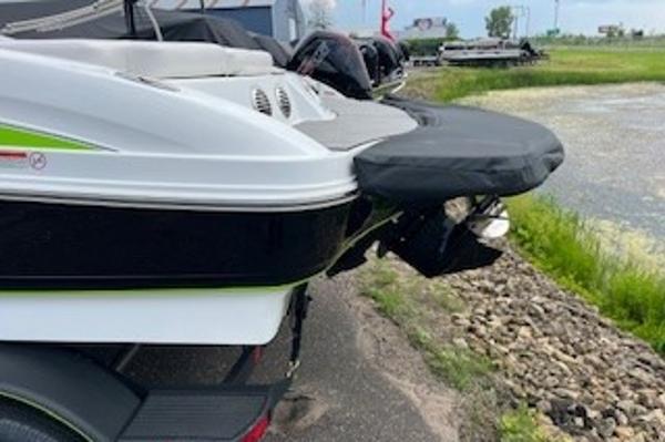 2024 Tahoe 210 Si boat rear view by a lakeside.