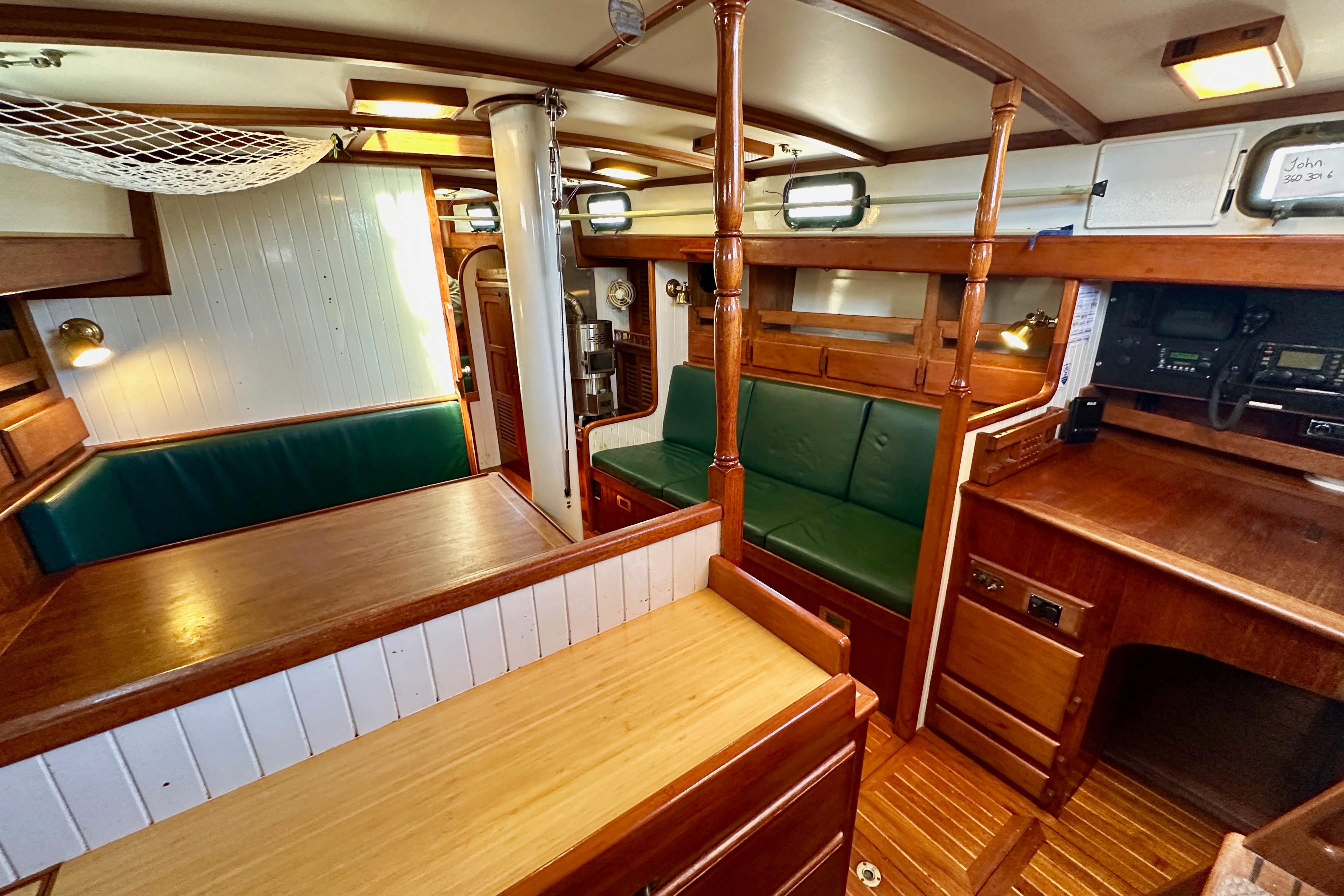 Interior of a 1981 Kelly Peterson 46 sailboat, featuring wooden furnishings and green seating.