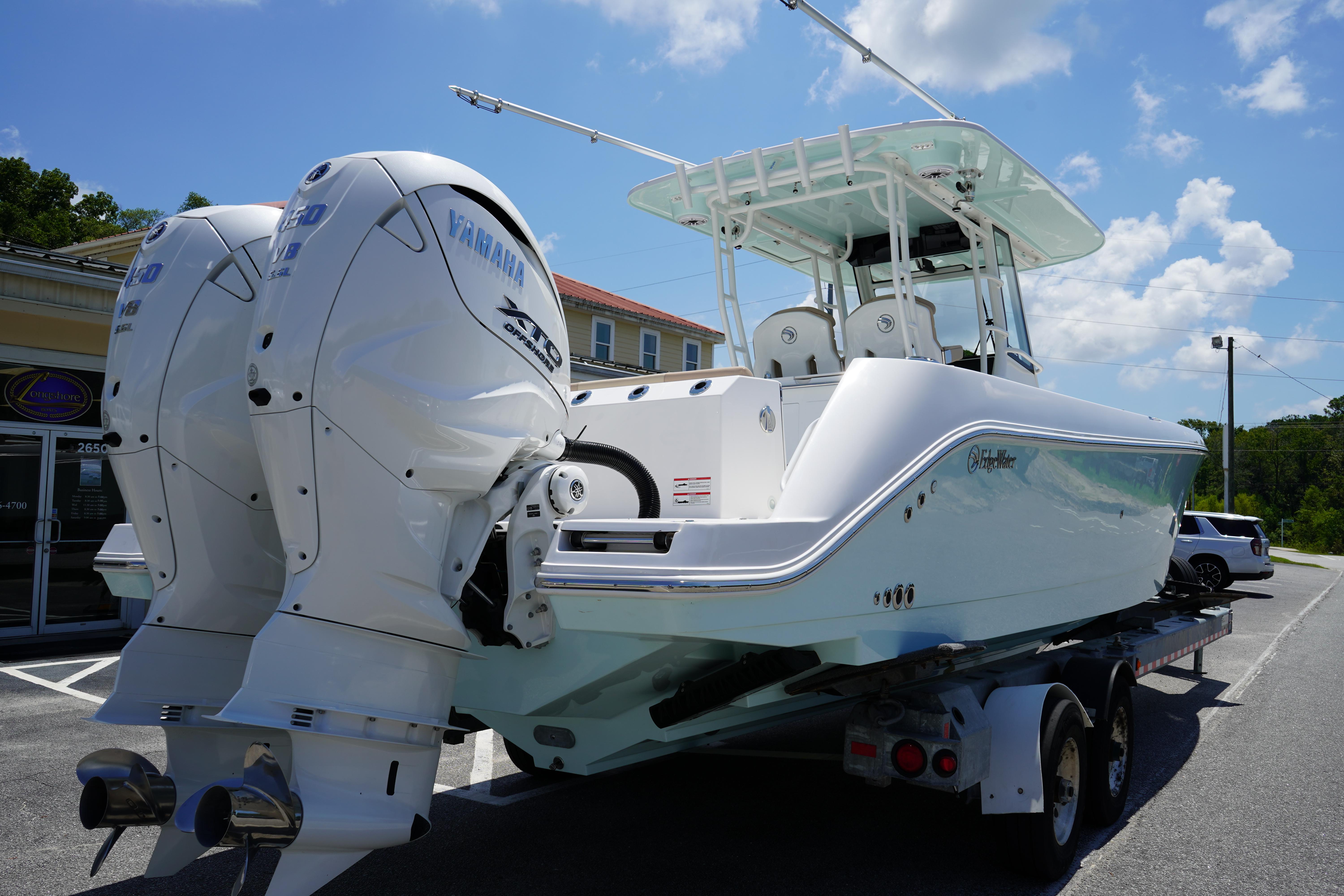 2025 Edgewater 340CC boat with twin Yamaha engines on a trailer under a clear sky.