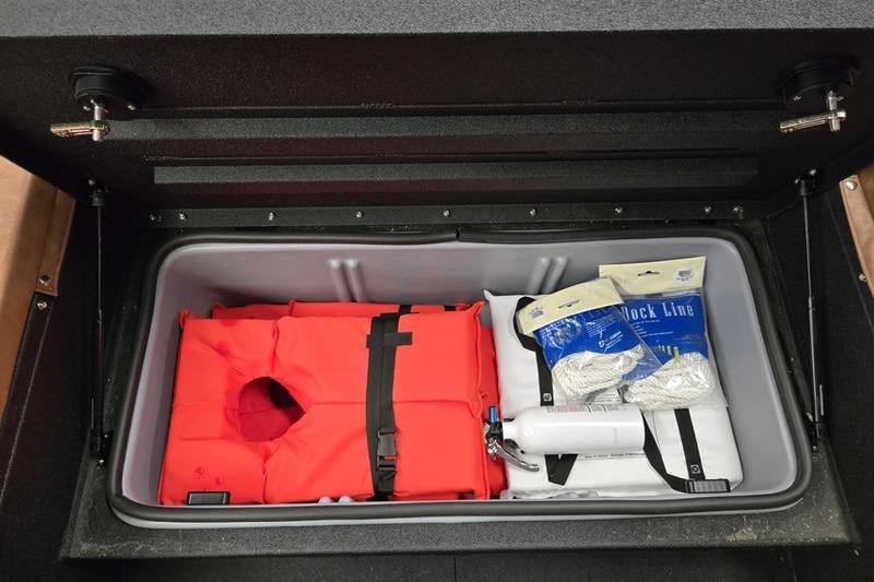 Storage compartment in Avid 207 Recon 2026 with life jacket and boating gear.