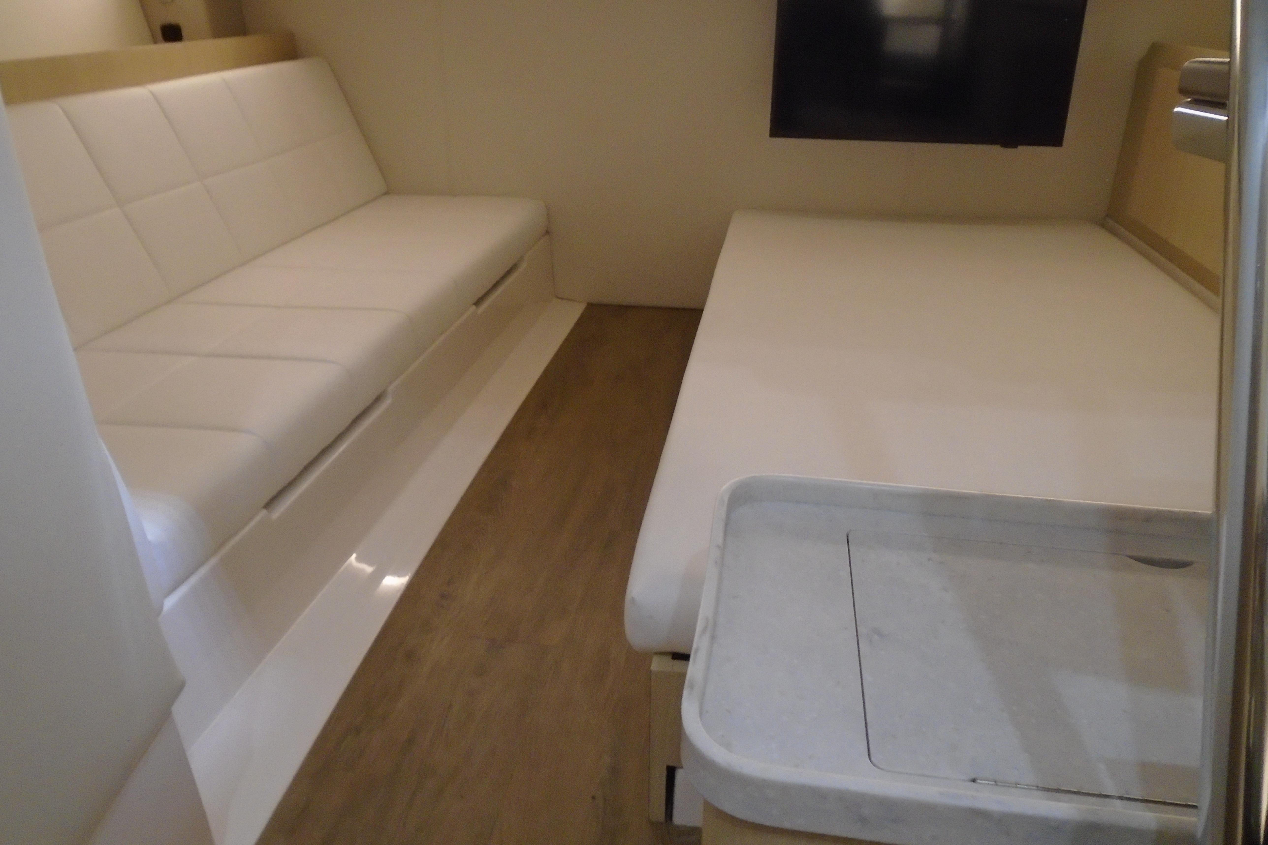 Interior of 2026 Regal 38 SAV yacht with modern seating and wooden flooring.
