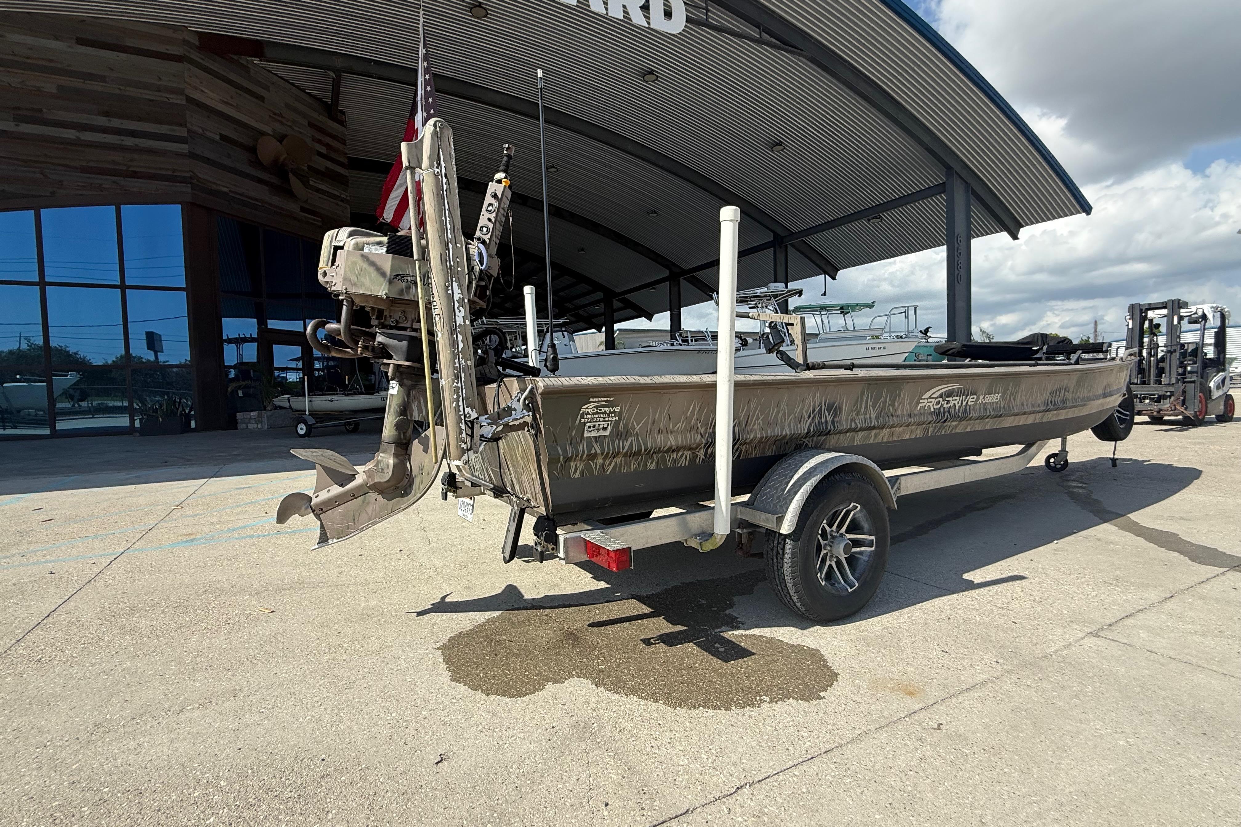 2017 Pro-Drive 2048 boat on trailer outside a modern building, showcasing its motor and design.