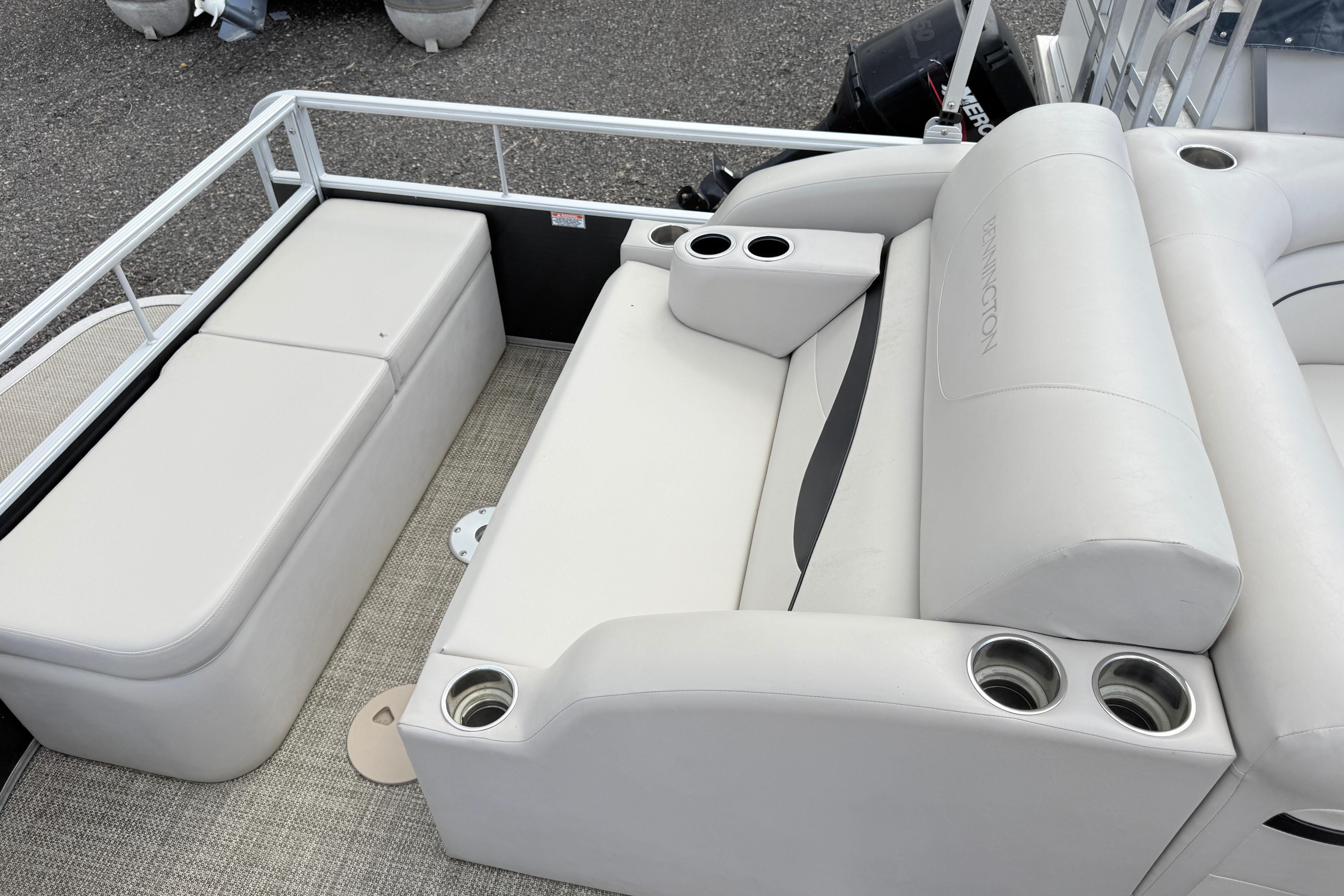 2015 Bennington 24SSLX pontoon boat interior with white seating and cup holders.