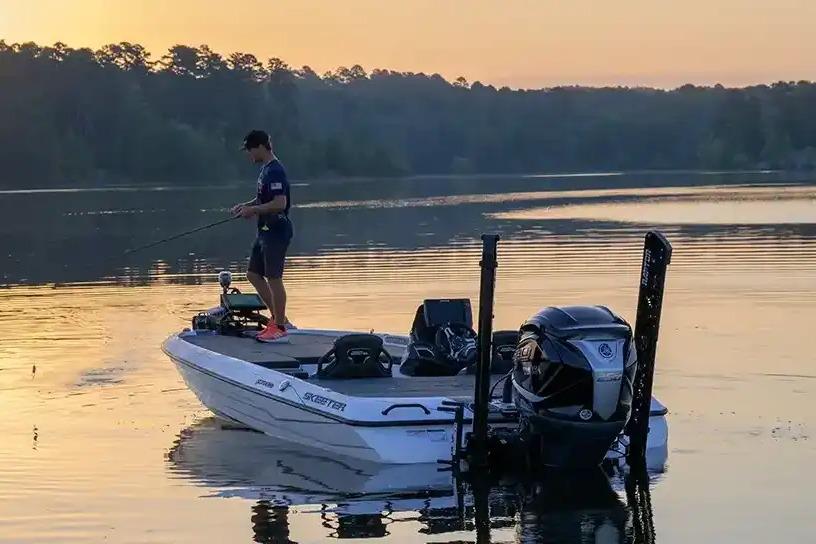 Manufacturer Provided Image: Man fishing on a 2026 Skeeter FXR20 FLEX boat at sunrise on a calm lake.