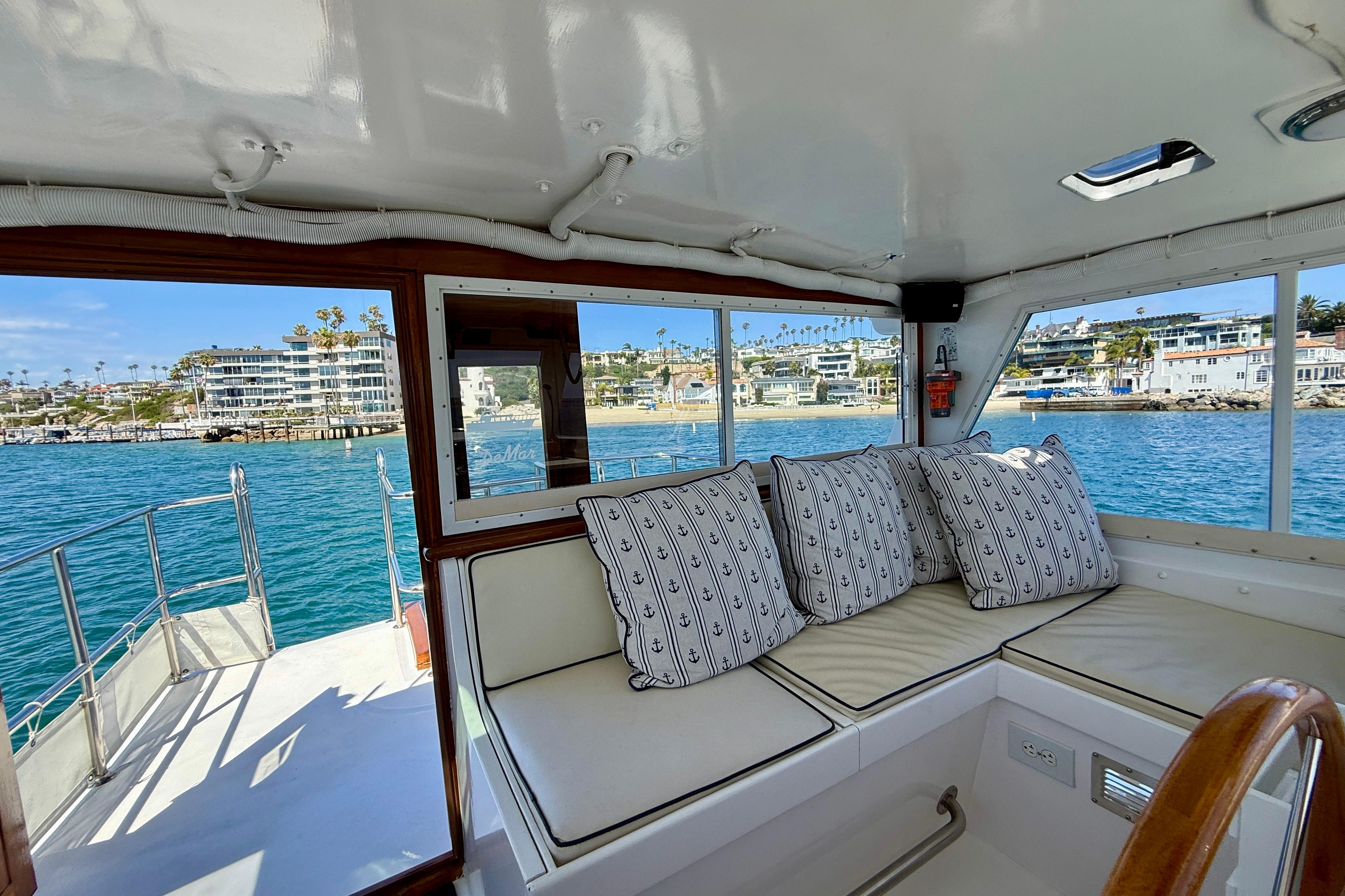 Interior of 1980 Roughwater 41 yacht with coastal view and nautical-themed cushions.