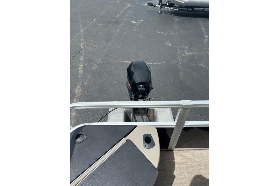 2023 SUNTRACKER Fishing Barge 20 with outboard motor on a trailer.