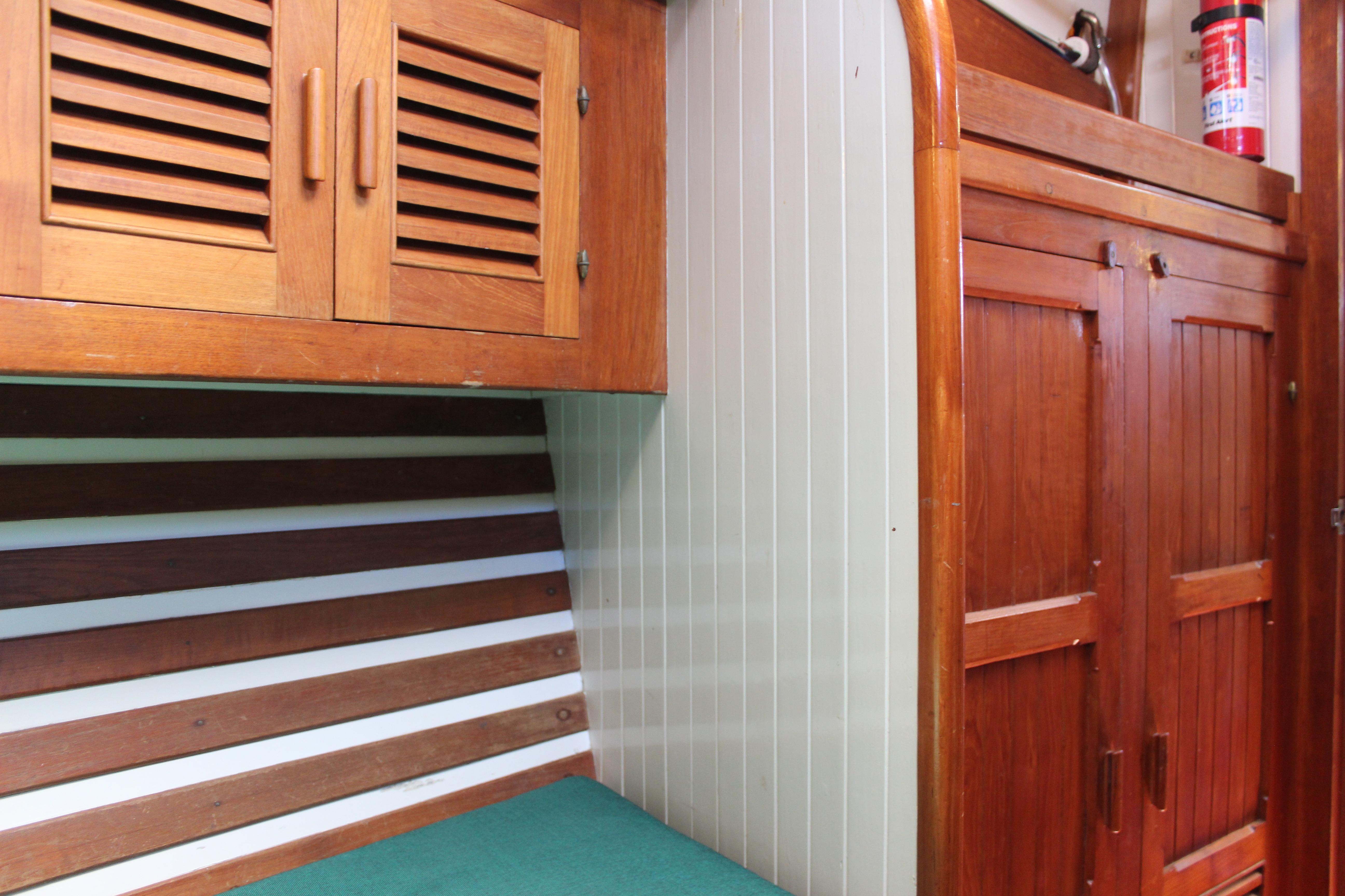 Interior of 1981 Kelly Peterson 46 sailboat with wooden cabinets and fire extinguisher.