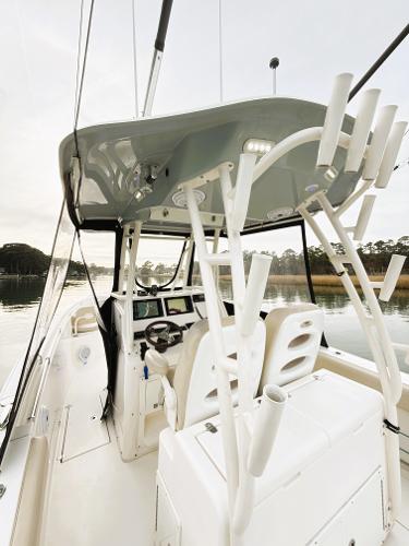 2016 Cobia 296 Center Console boat with helm and seating, docked on calm water.