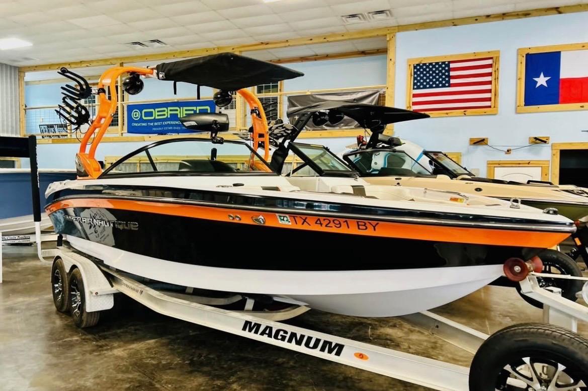 2013 Nautique Super Air Nautique 230 boat on trailer in showroom.