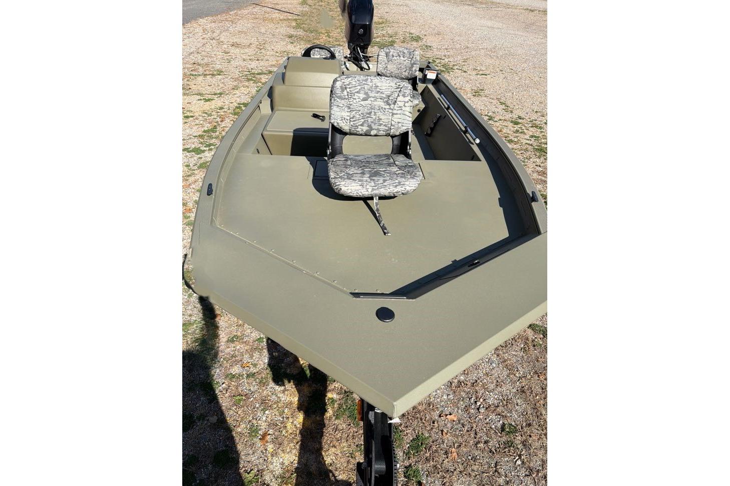 2026 Tracker Grizzly 1754 SC boat with camouflage seats on a dry surface.