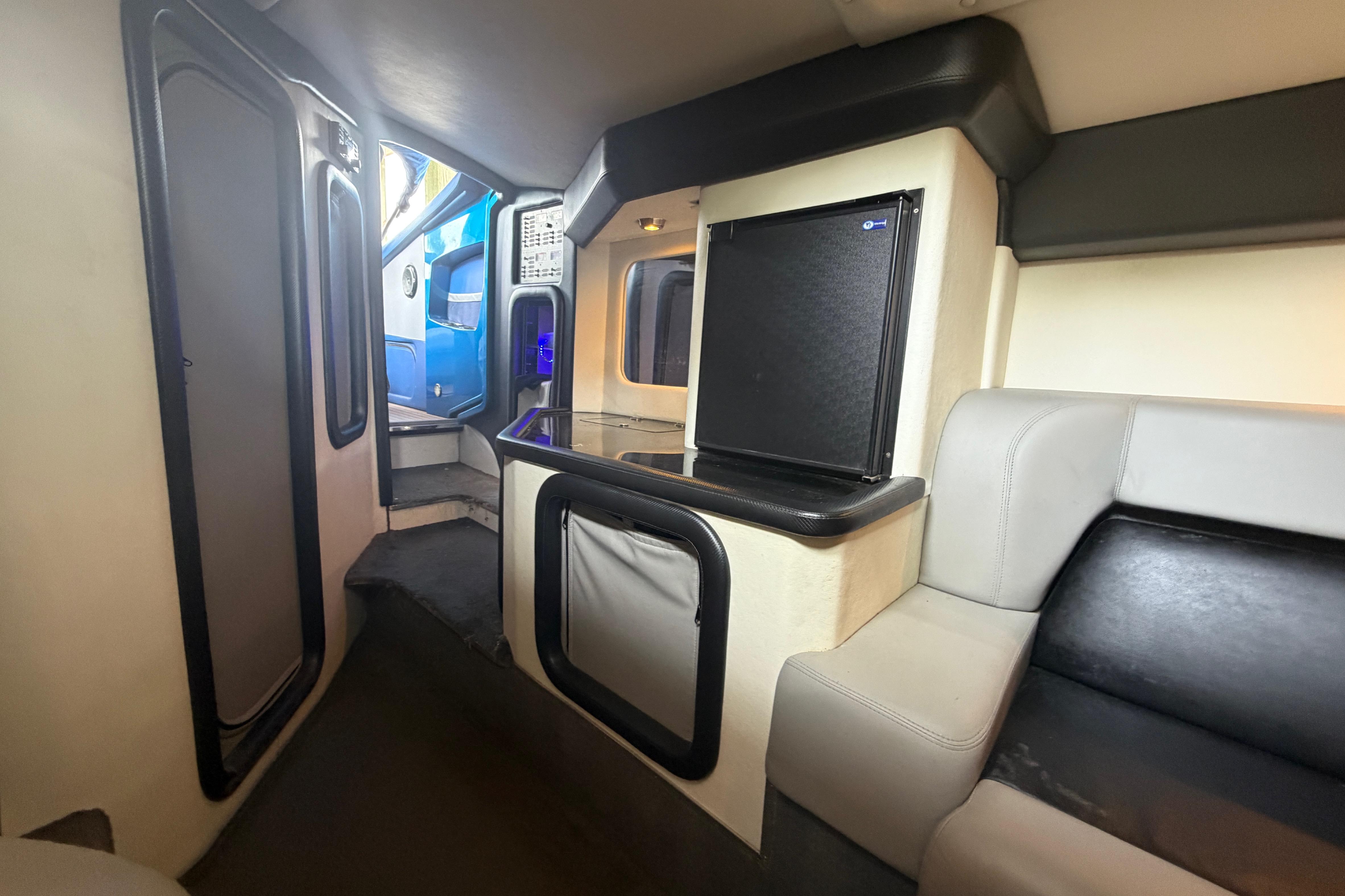 Interior of 2013 Nor-Tech 477 SPX Vee Bottom boat, featuring seating and compact kitchenette.