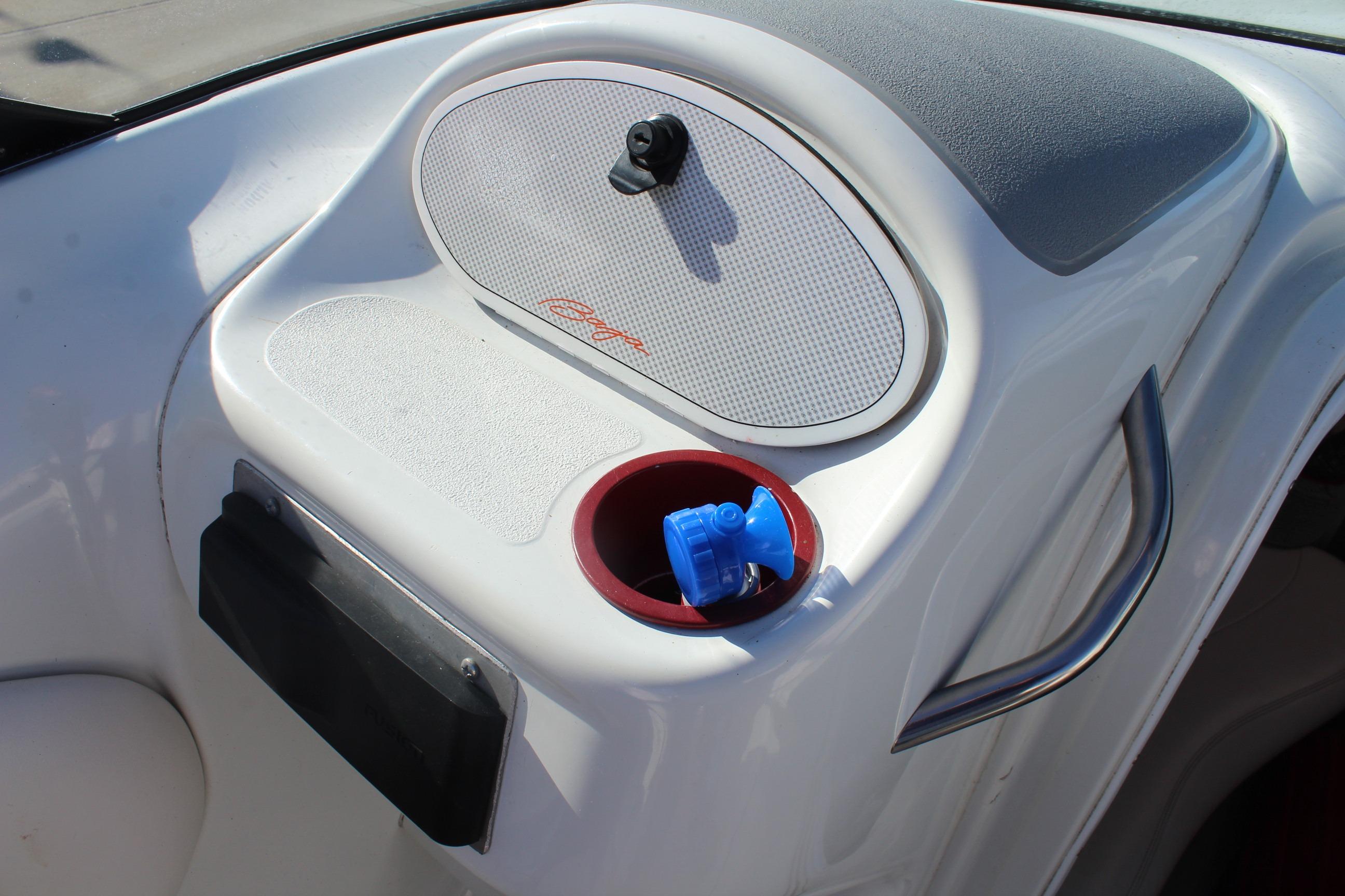 Interior of a 1996 Baja 232 boat with speaker and cup holder.