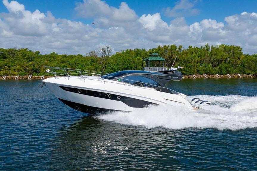 2022 Schaefer 400 Sport yacht cruising on a scenic waterway with lush greenery.