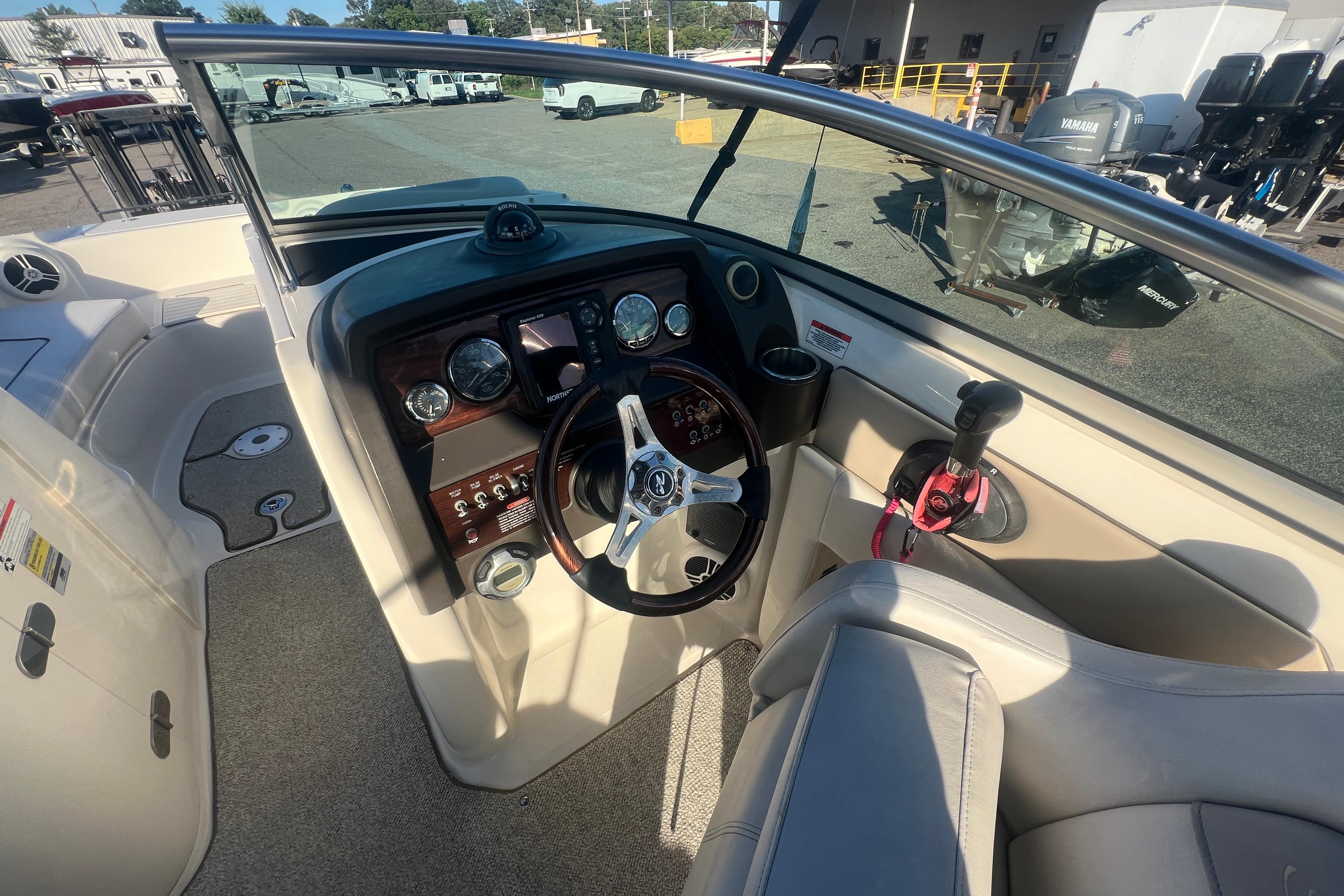 Interior view of 2009 Sea Ray 210 Sundeck boat cockpit with steering wheel and controls.