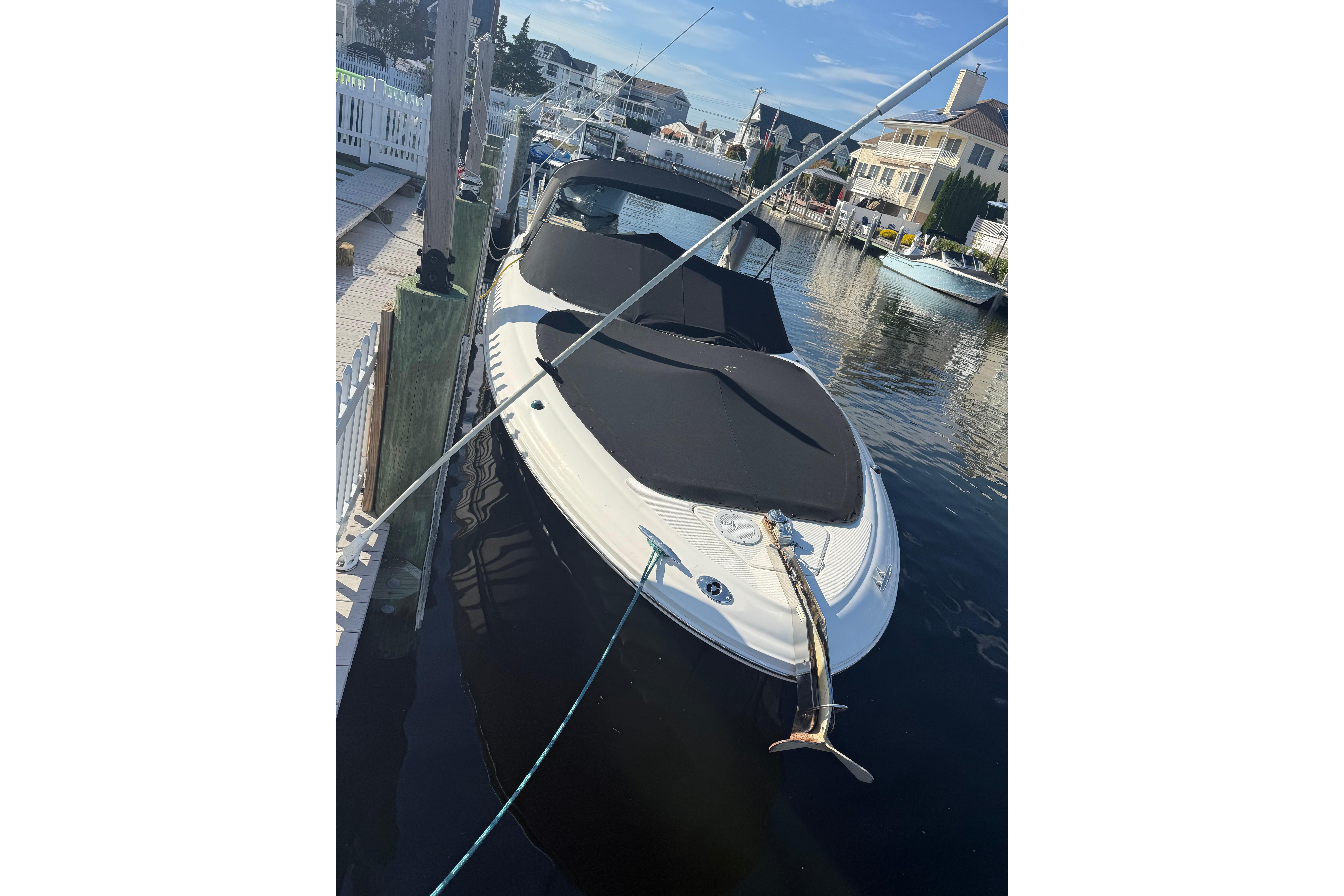 2005 Sea Ray 290 SLX boat docked at marina, covered and secured.