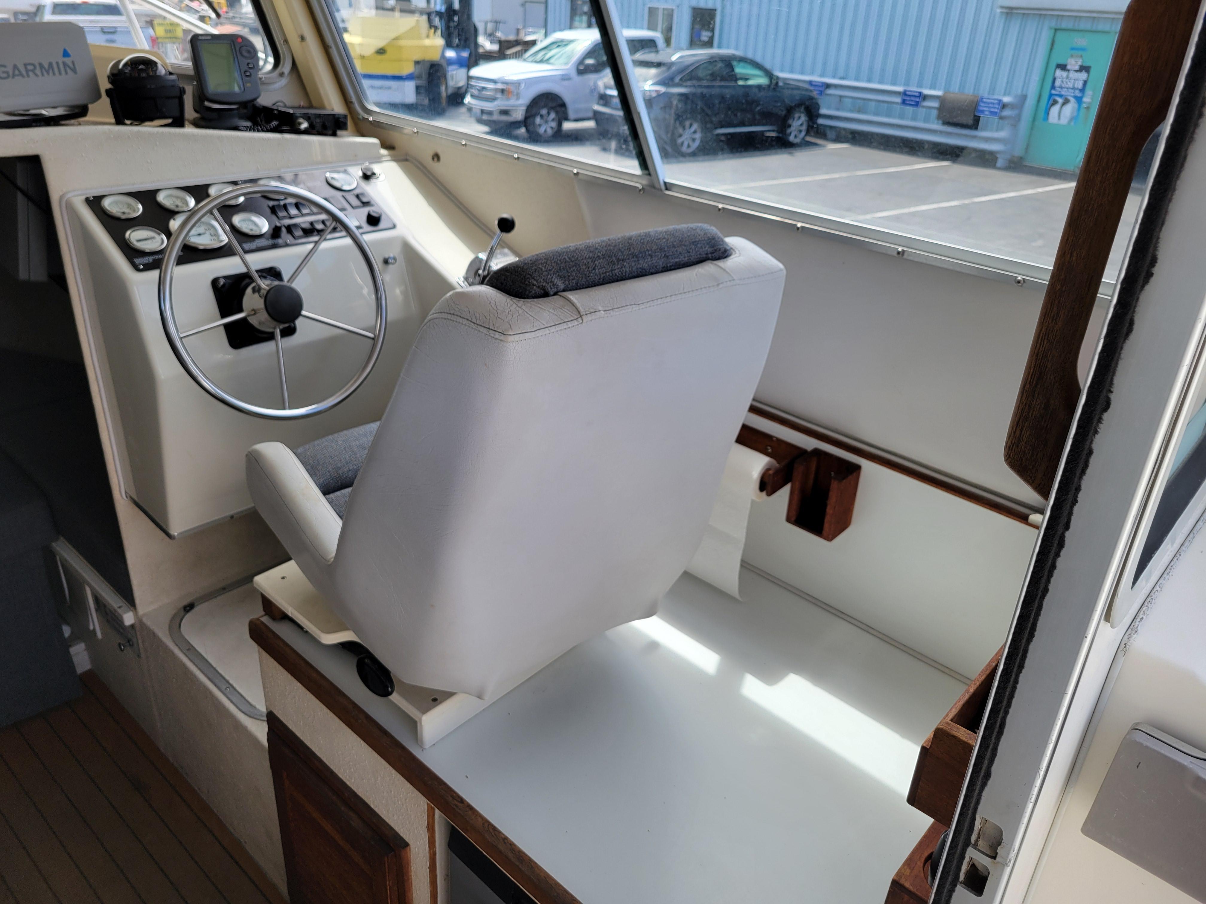 Interior of 1999 SeaSport 2400 XL Limited boat with steering wheel and captain's chair.
