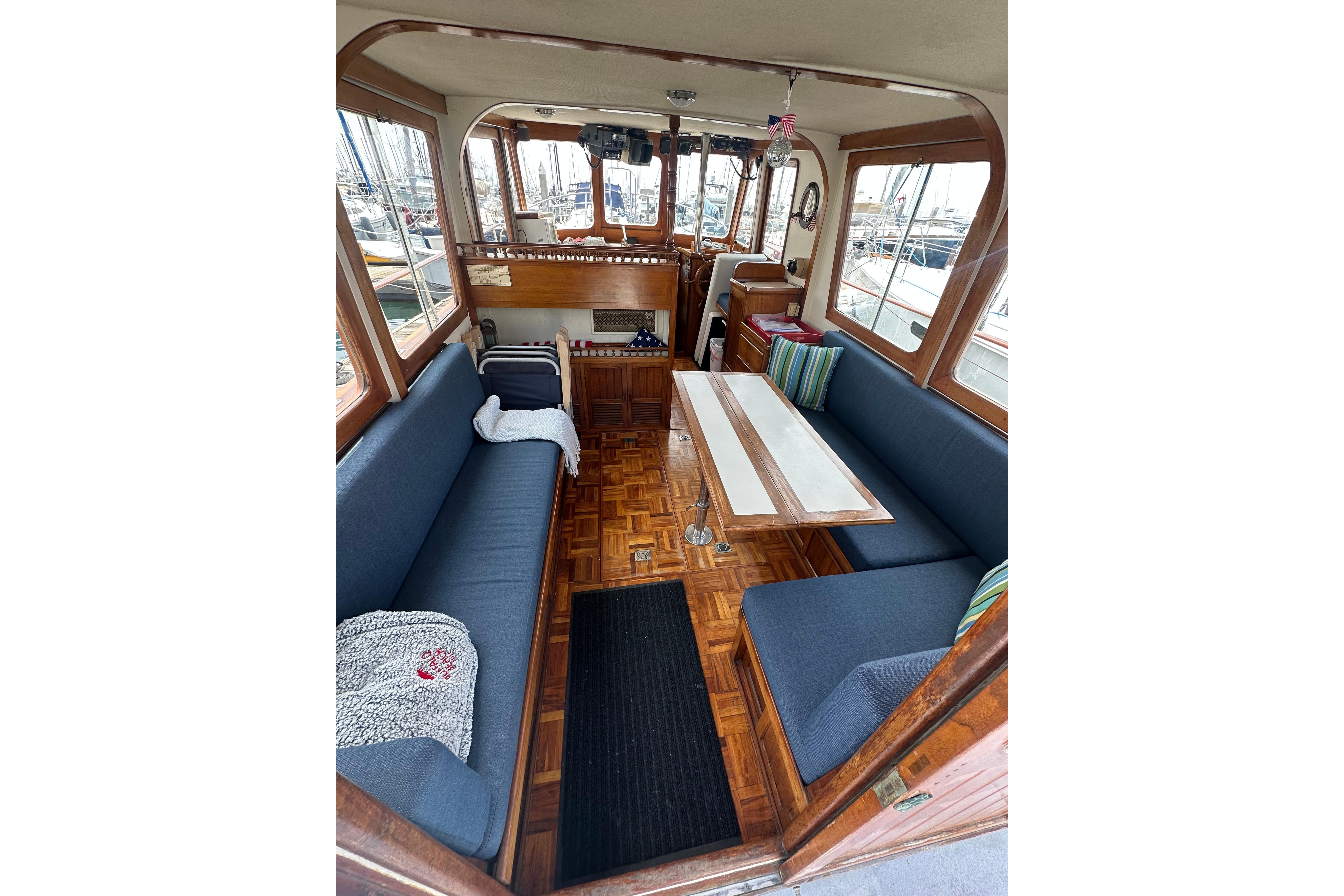 Interior of a 1973 CHB 33 boat with blue seating and wooden accents.
