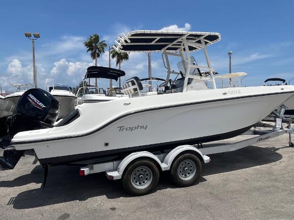 2022 Bayliner Trophy T22CC boat on trailer, parked outdoors under clear sky.