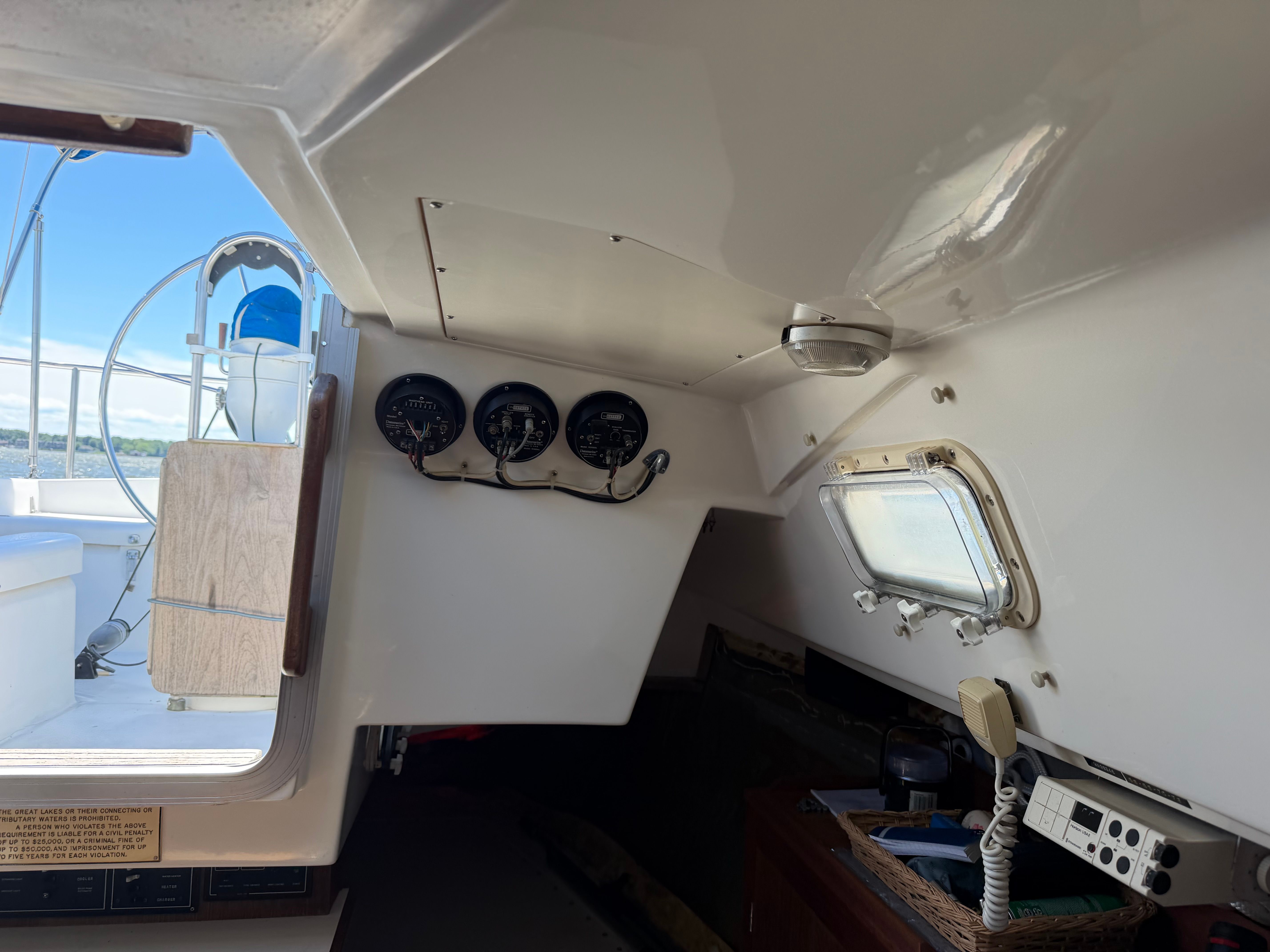 Interior view of a sailboat with instruments and a window.