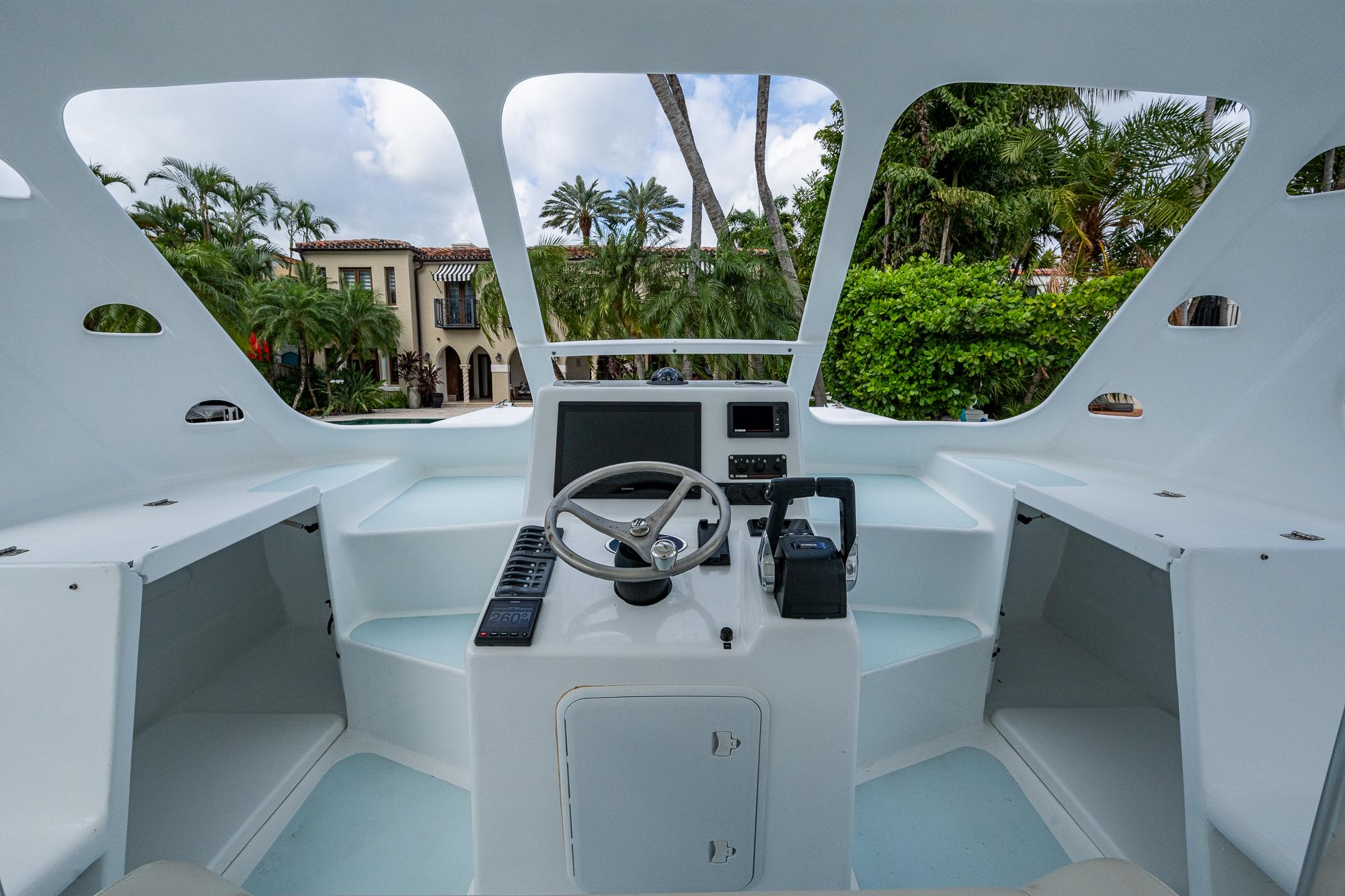 Cockpit of 2019 Aventura 31 Cat boat with steering wheel and control panel.