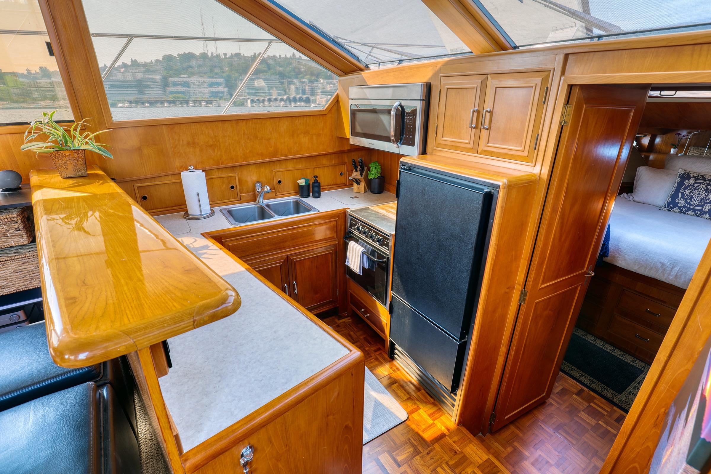 1987 Ocean Alexander 480 Sport Sedan interior with wood cabinetry, kitchen, and cozy bedroom.
