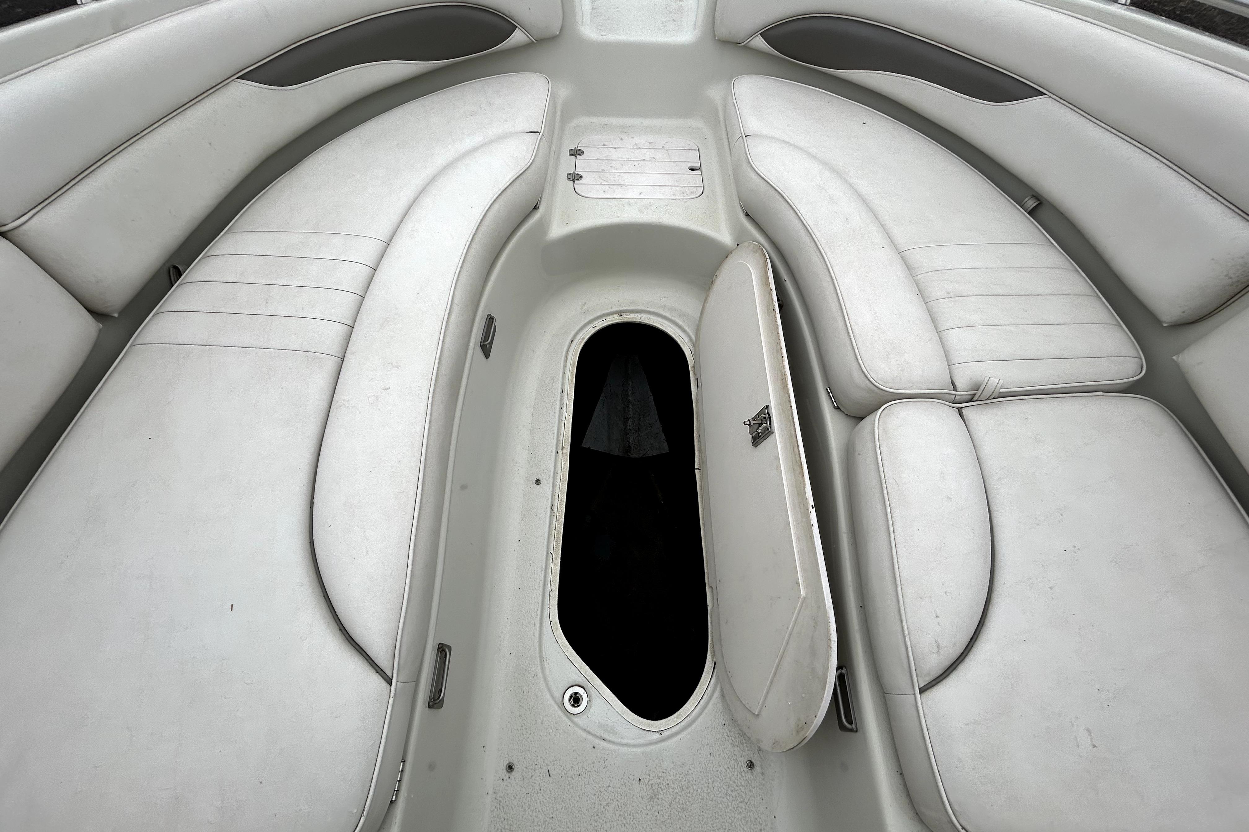 2001 Crownline 239 DB boat interior with white seating and open storage compartment.