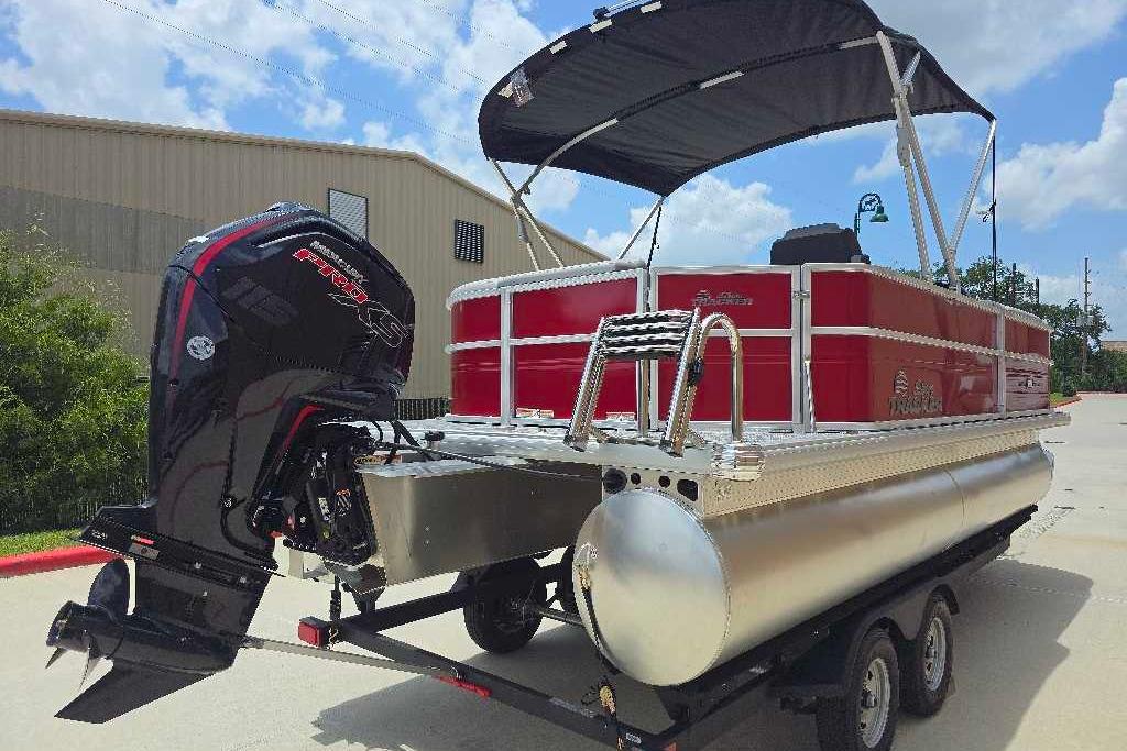 2026 Sun Tracker Party Barge 20 DLX pontoon boat with outboard motor on trailer.
