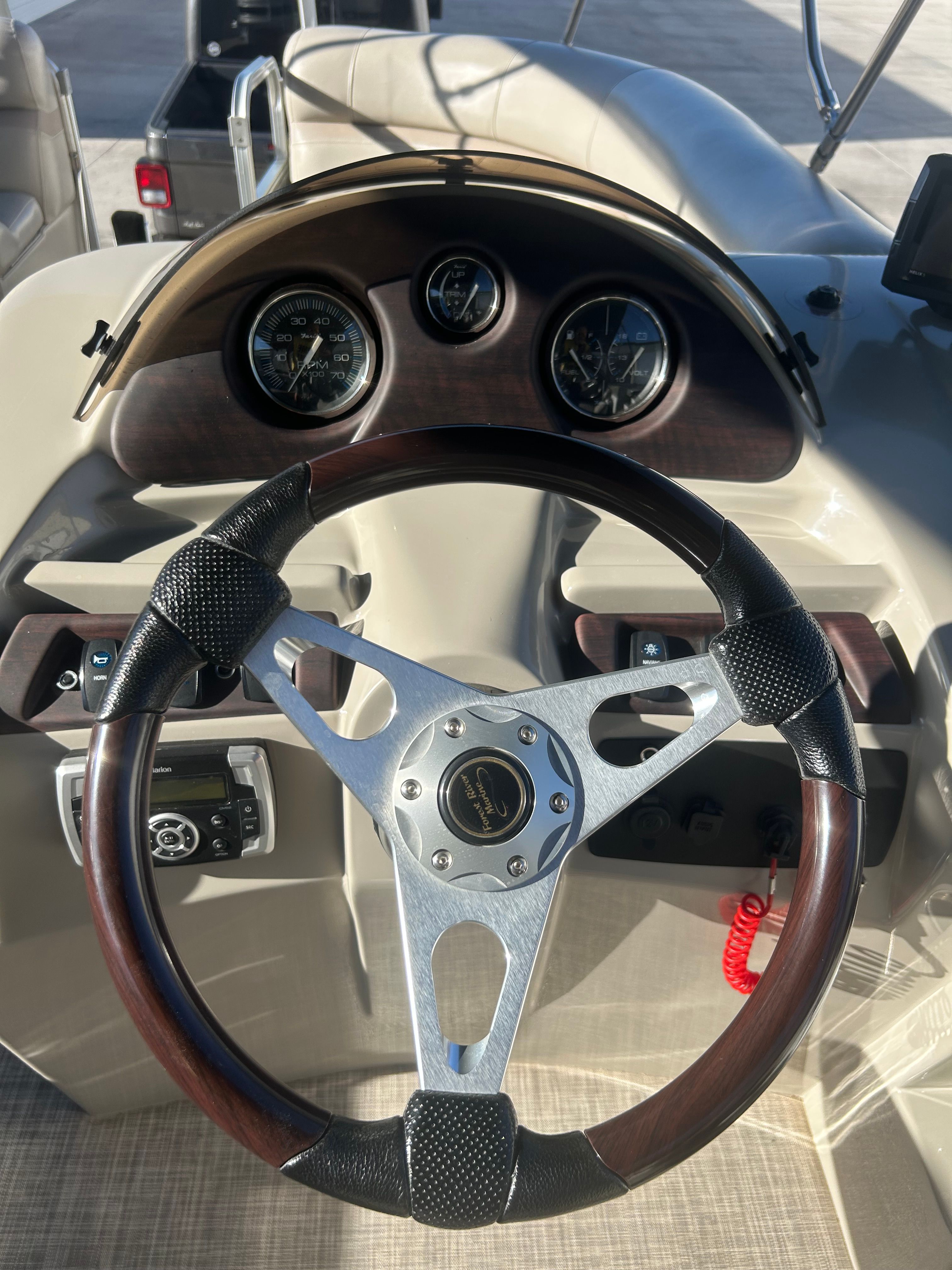 The image shows the helm of a 2018 Berkshire 24RFX CTS boat with sleek wood and metal elements.