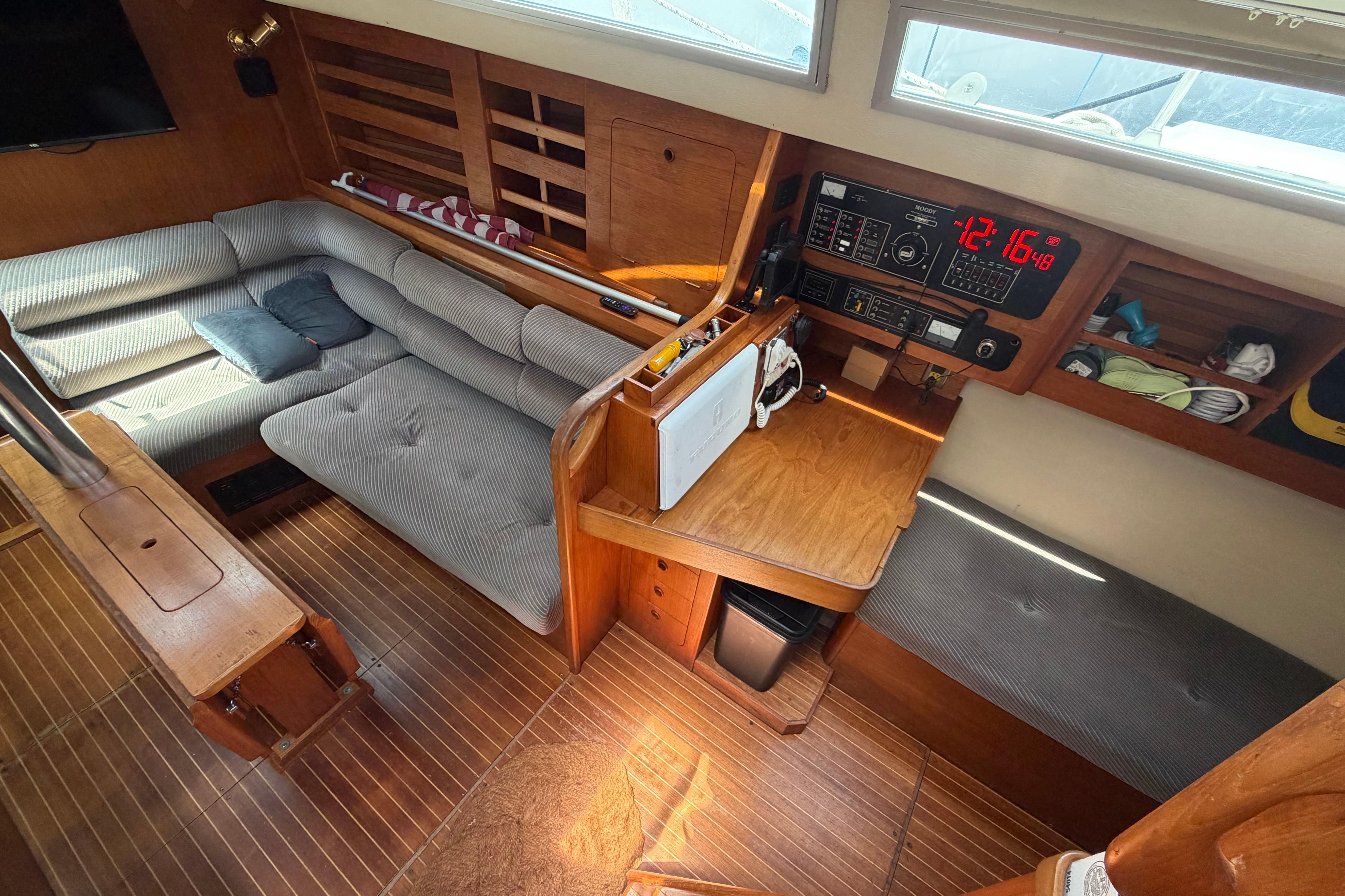 Cozy interior of a 1987 Moody 376 sailboat with seating and navigation area.