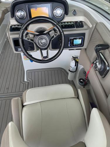 2019 Crownline E255 boat cockpit with steering wheel, control panel, and beige seating.