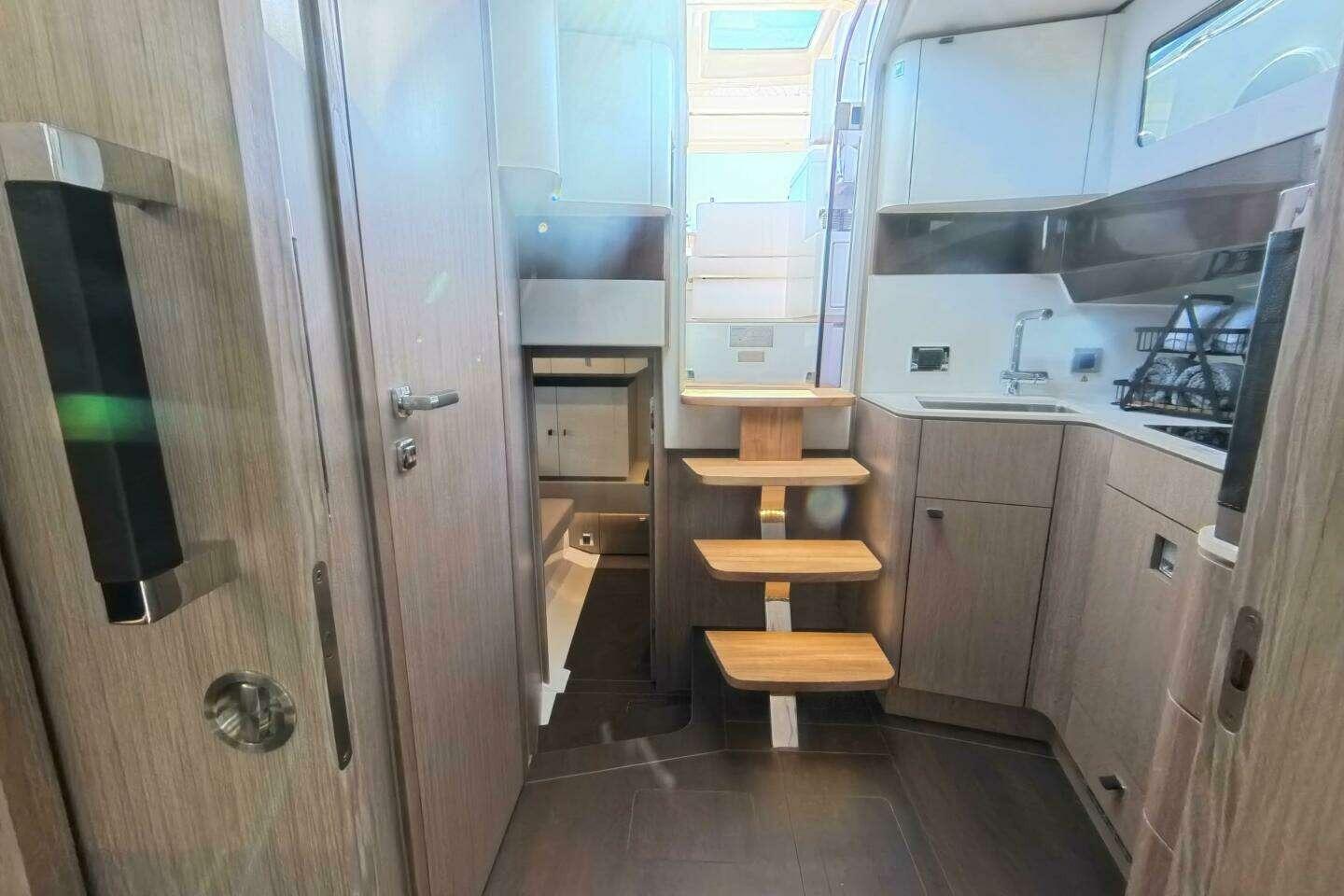 2024 Fjord 41XP yacht interior with modern kitchen and wooden stairs.