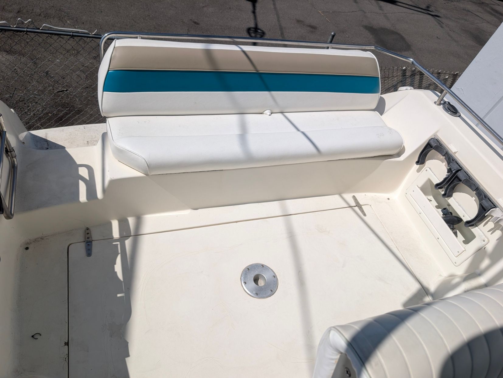 The image shows the cockpit of a 1995 Rinker Fiesta Vee 265 with white and blue seating.